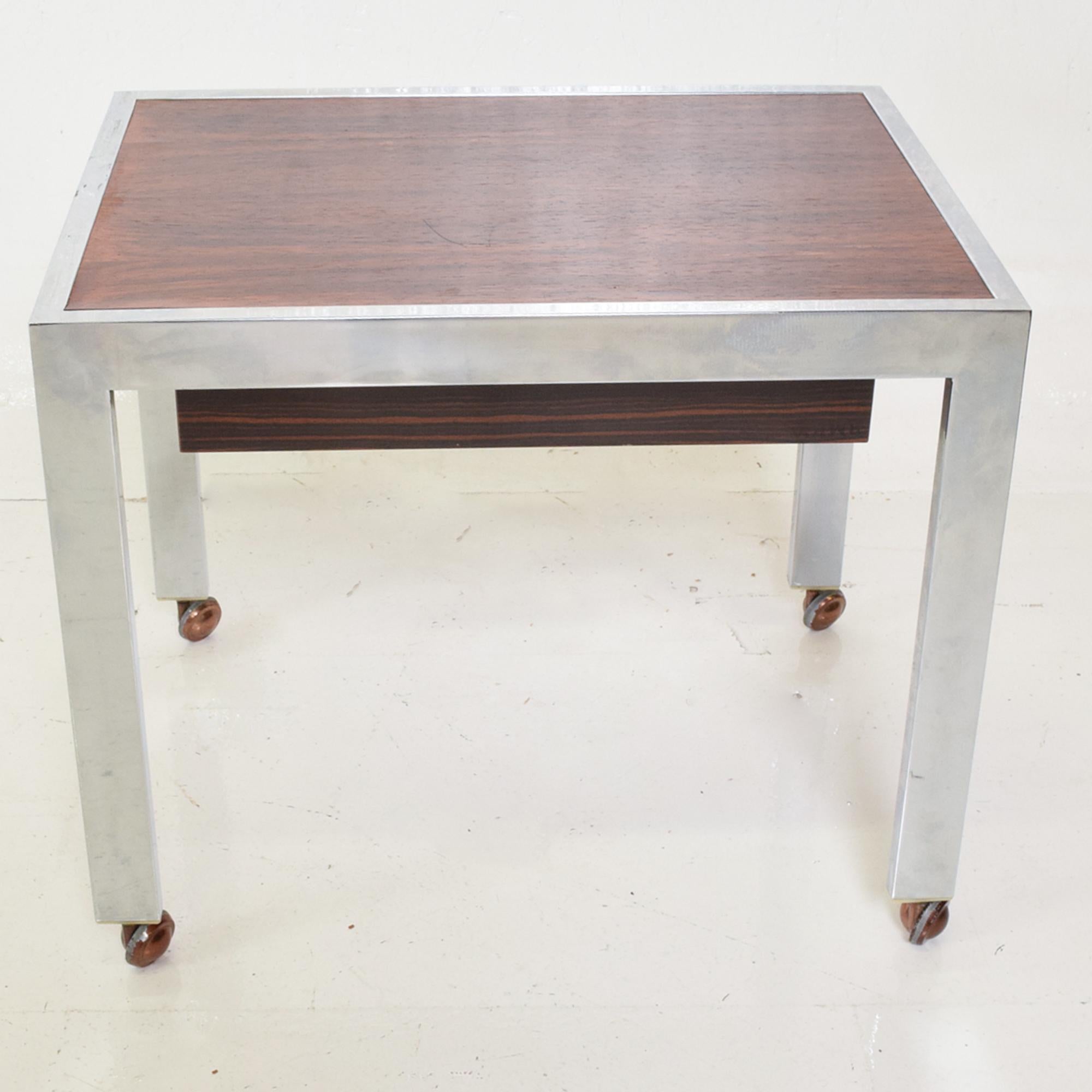 Scandinavian Danish modern sleek rectangular side table rosewood & chrome on rolling casters
Single recessed rosewood drawer. Denmark circa 1960s. Unmarked. Reminiscent of Milo Baughman design.
Dimensions: 20 x 15 x 16.75 H, Drawer 2.25 H x 13.5 D