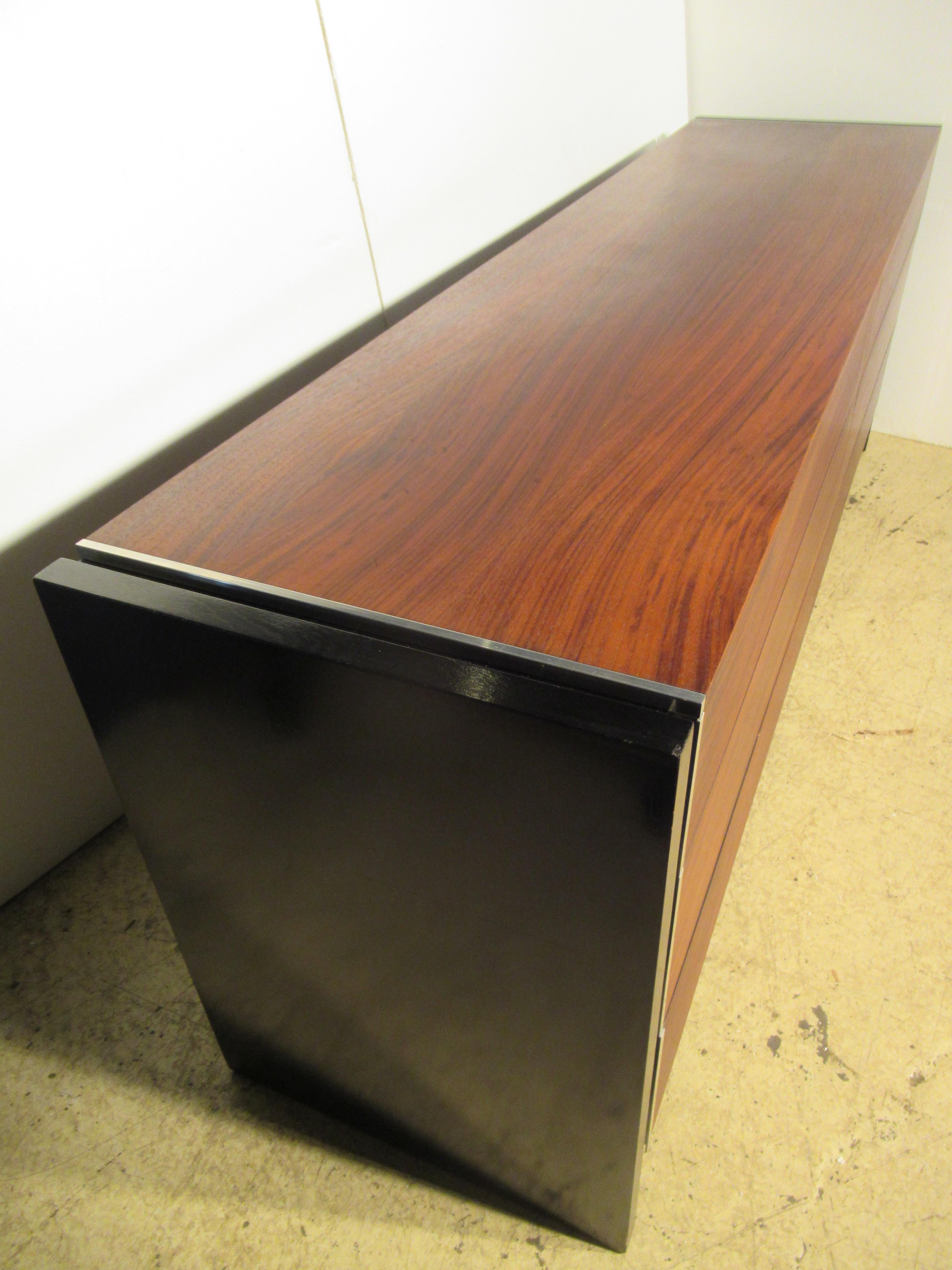 Long sleek minimalist dresser credenza having six-book matched richly grained rosewood drawers with finely machined polished aluminium fittings / a rosewood top and ebonized oak sides - designed by Robert Baron for Glenn of California and retailed