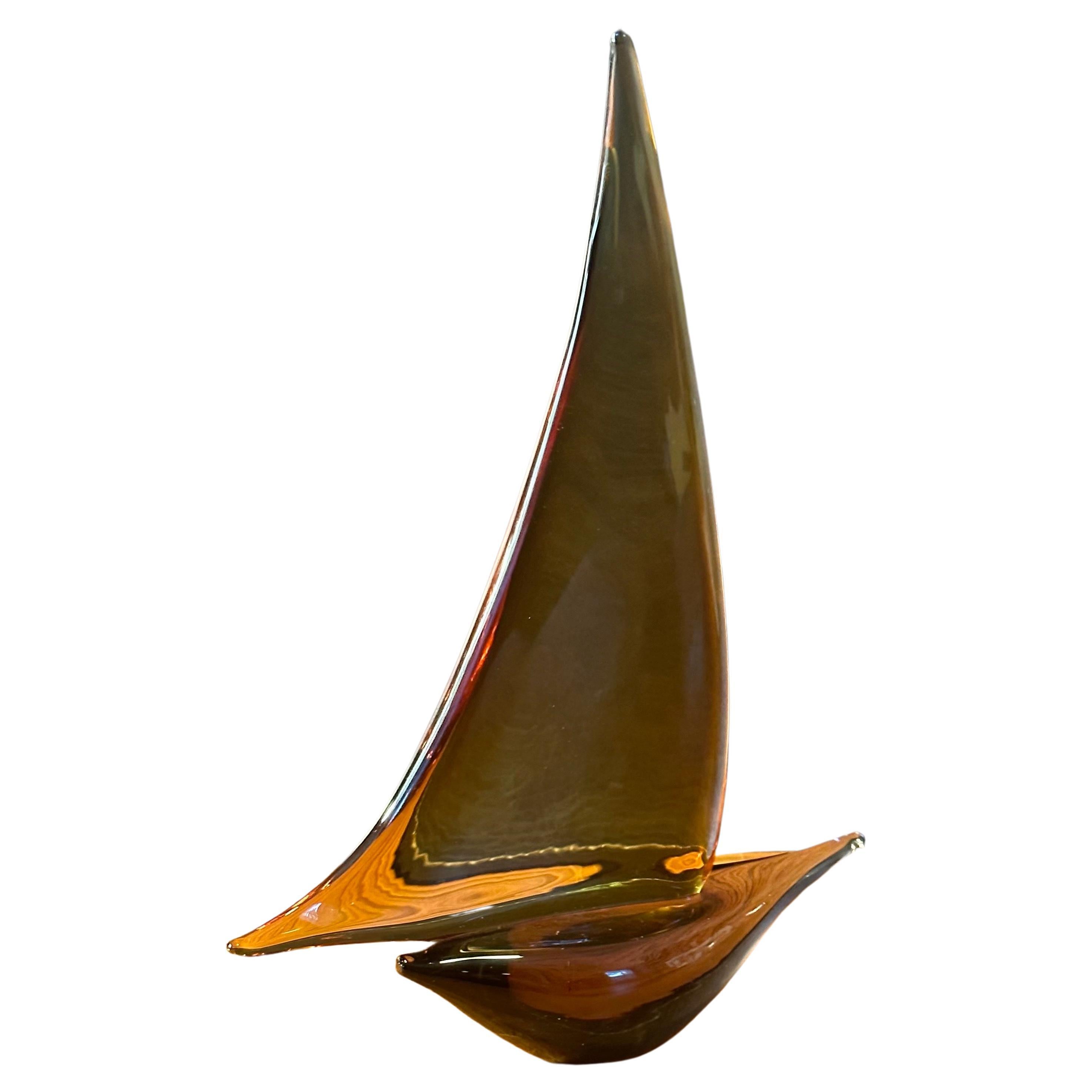 Sleek sailboat sculpture in amber art glass by Murano Glass, circa 1970s. The sailboat is in very good vintage condition with no chips or cracks and measures 9.5