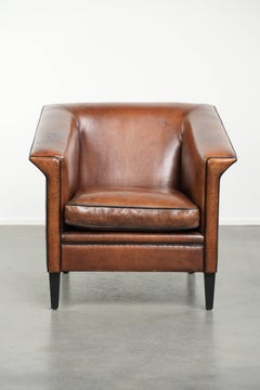 Sleek sheepskin Art Deco design armchair with black piping