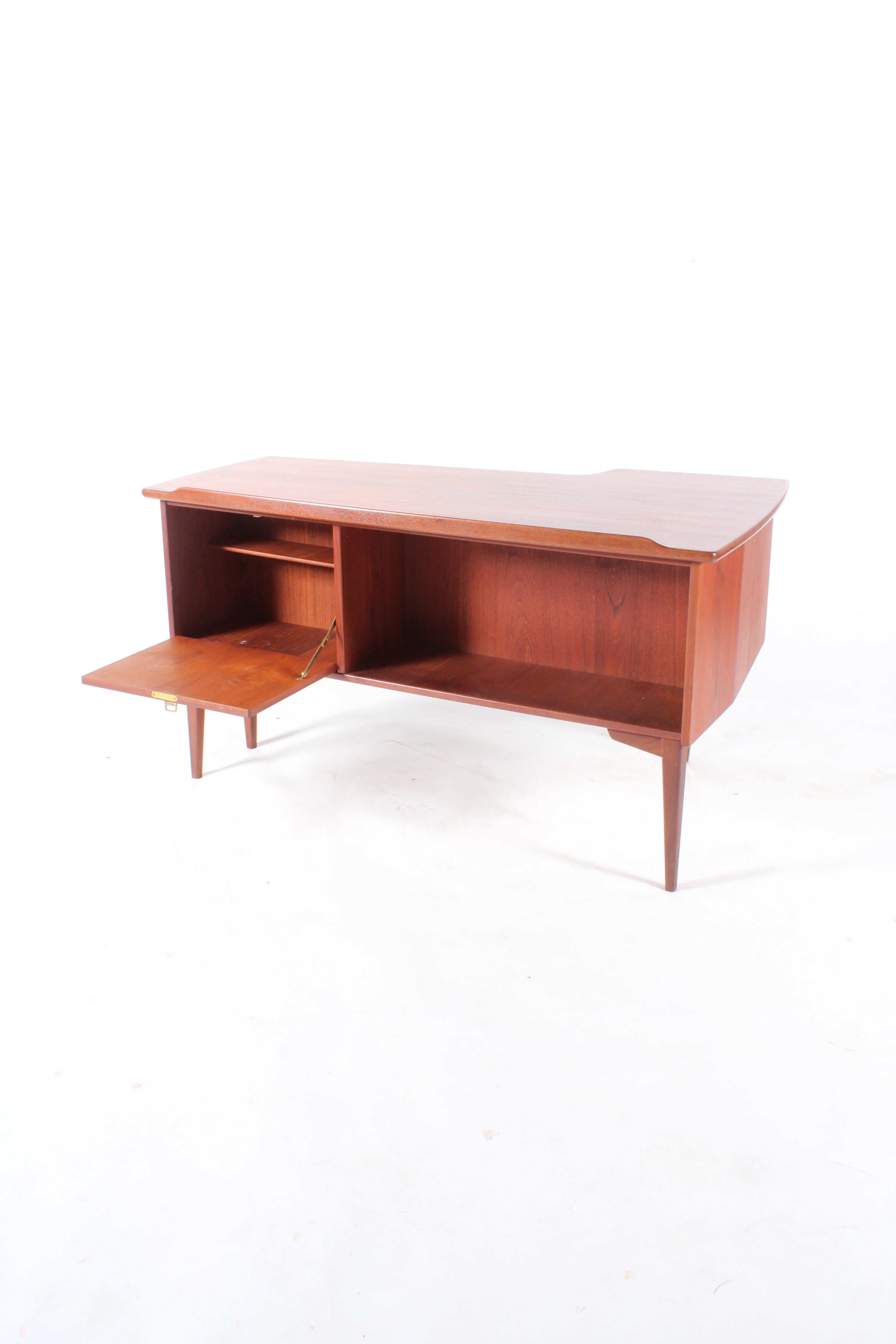 Acquired è lieta di presentare in vendita questa splendida scrivania originale di metà secolo a forma di boomerang in teak. Una scrivania elegante e pratica, pronta per l'uso quotidiano. Lo spazio è costituito da tre cassetti estraibili con chiave