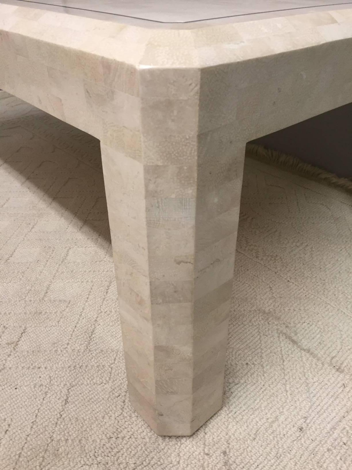 Stunning rectangular modern coffee table by Maitland-Smith made of off-white tessellated stone and having a simple carved dark brown line around the top periphery.