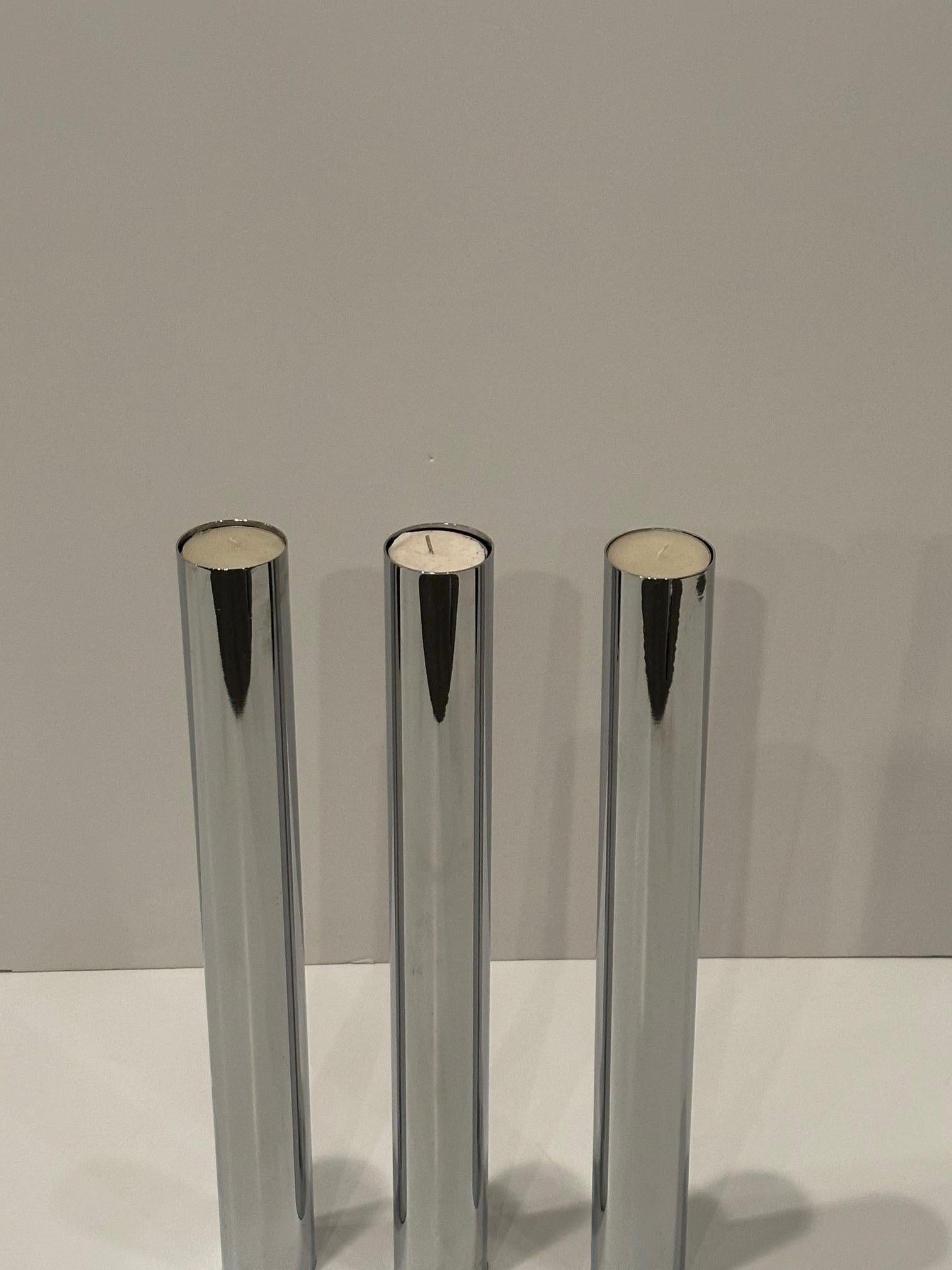 Elegante juego de 3 portavelas altos columnares de acero inoxidable.  Las votivas funcionan bien, o las velas gruesas.