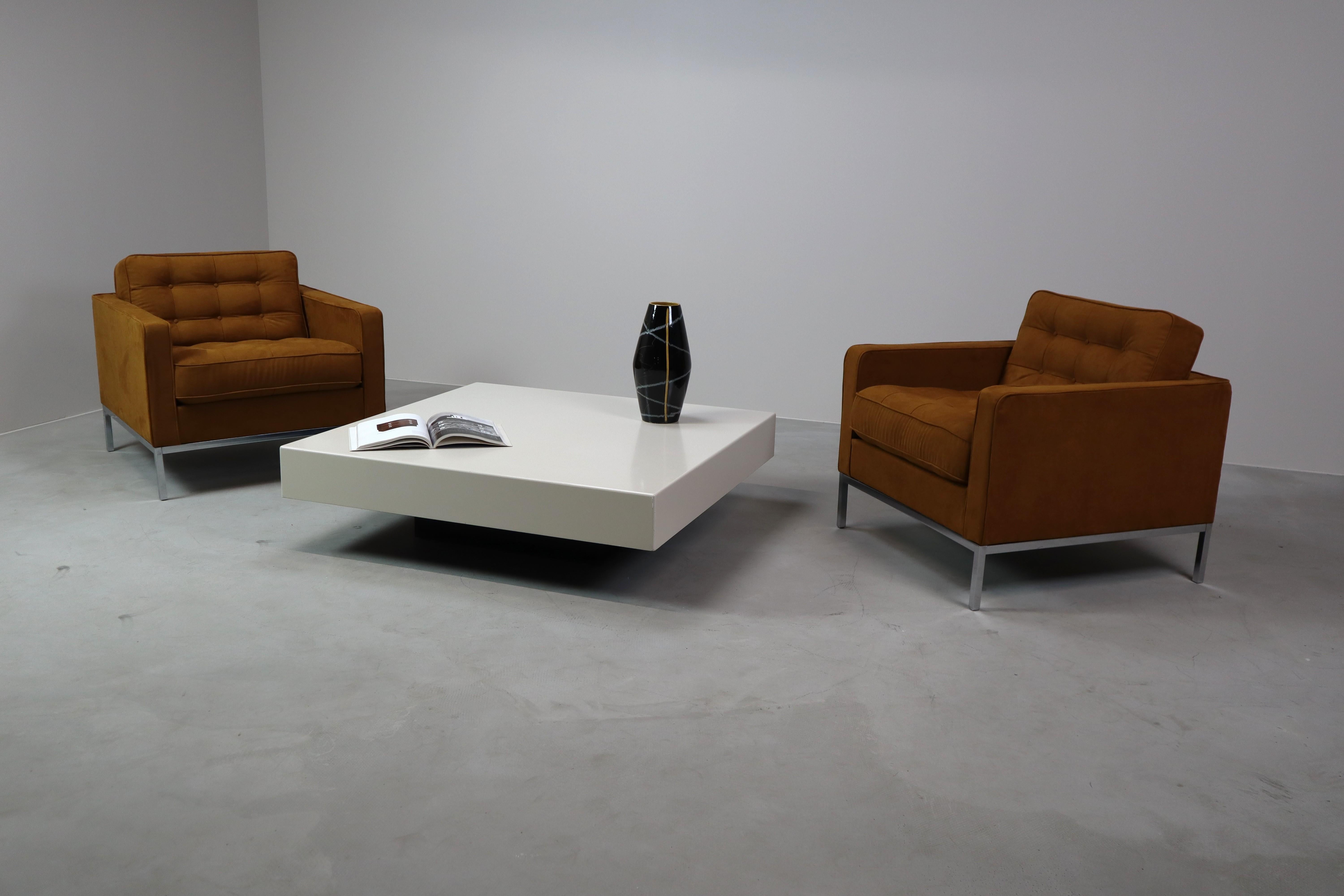This coffee table exudes timeless elegance with a modern minimalist design. The sleek, cube-like design features a thick wooden top, finished with a durable white plastic layer, which ensures a smooth and easy-to-clean surface. The black base, made