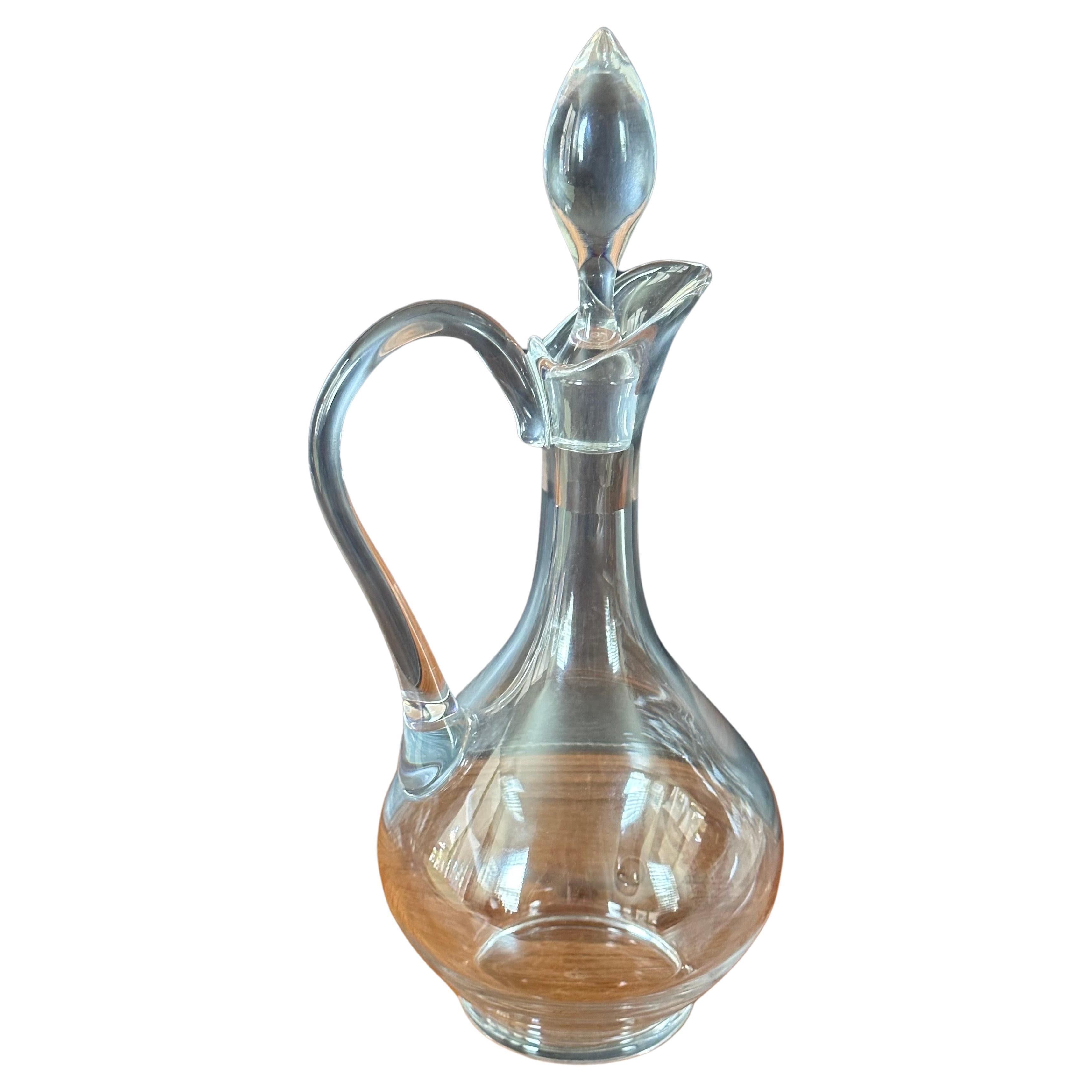 Stunning wine decanter with handle and stopper by Baccarat of France, circa 2000s. The piece is in great condition with no chips or cracks and measures 6.5