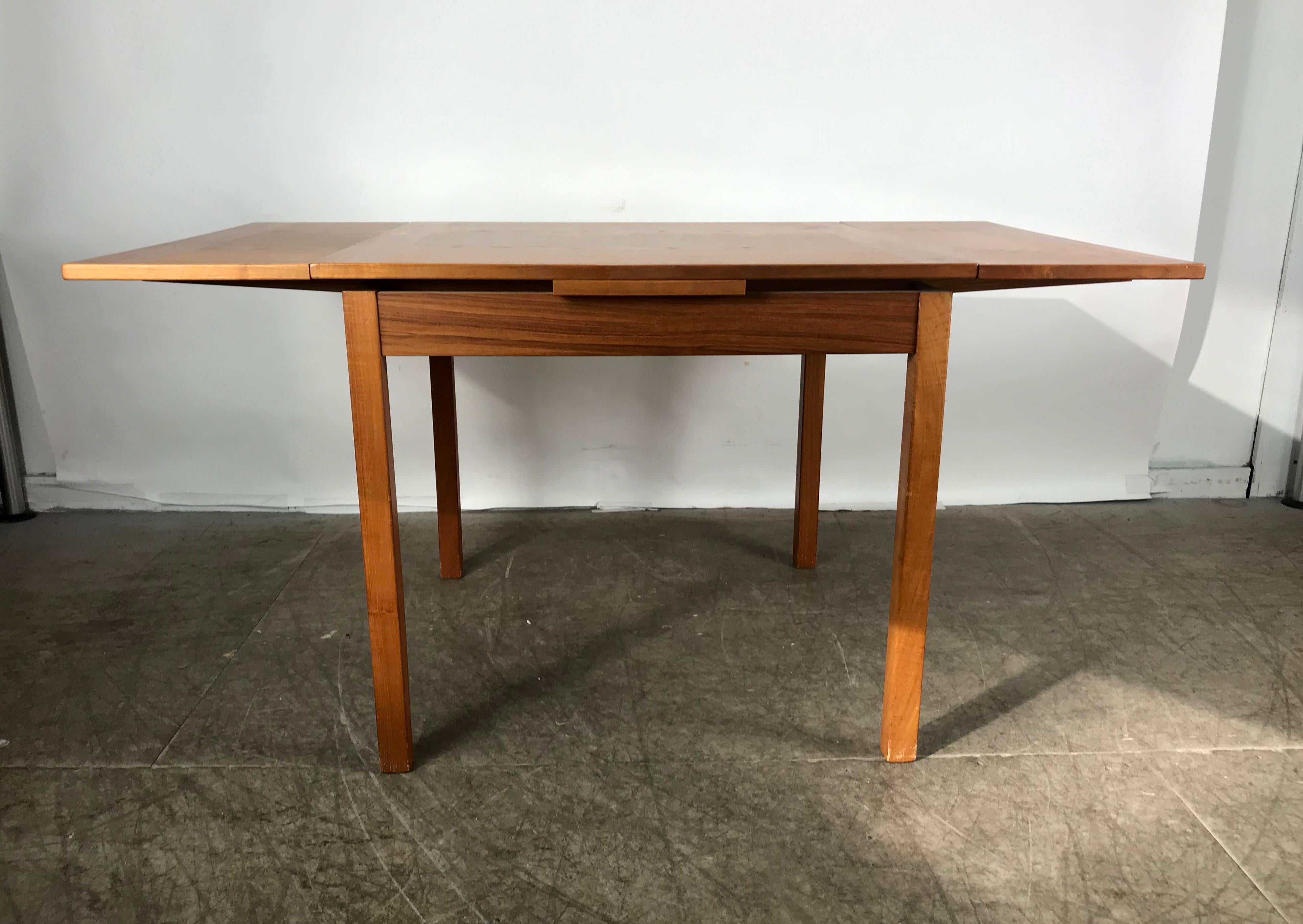 Sleek, simple expandable teak dining table made in Denmark. Measures: 33