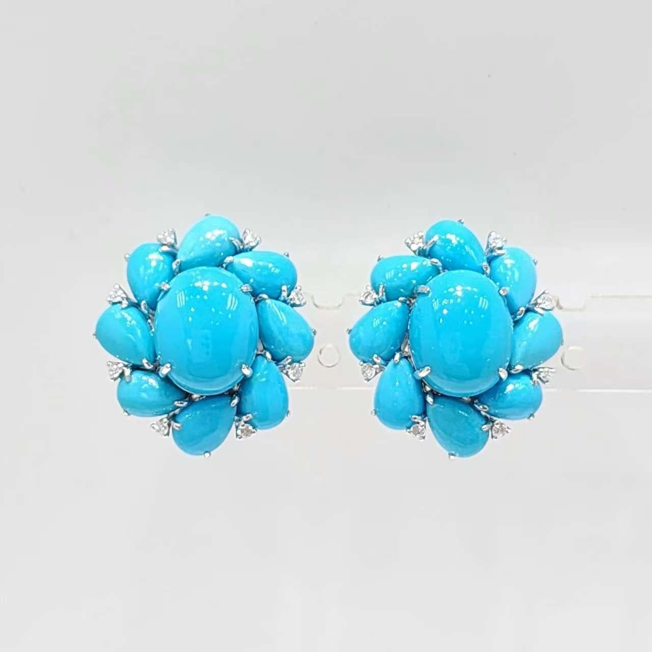 Realizzati in luminoso oro bianco da 14 carati, questi straordinari orecchini catturano la bellezza del turchese in un design audace ed elegante. Ogni pezzo presenta due gemme ovali di turchese, 8x10 mm, come accattivante punto focale, circondate da