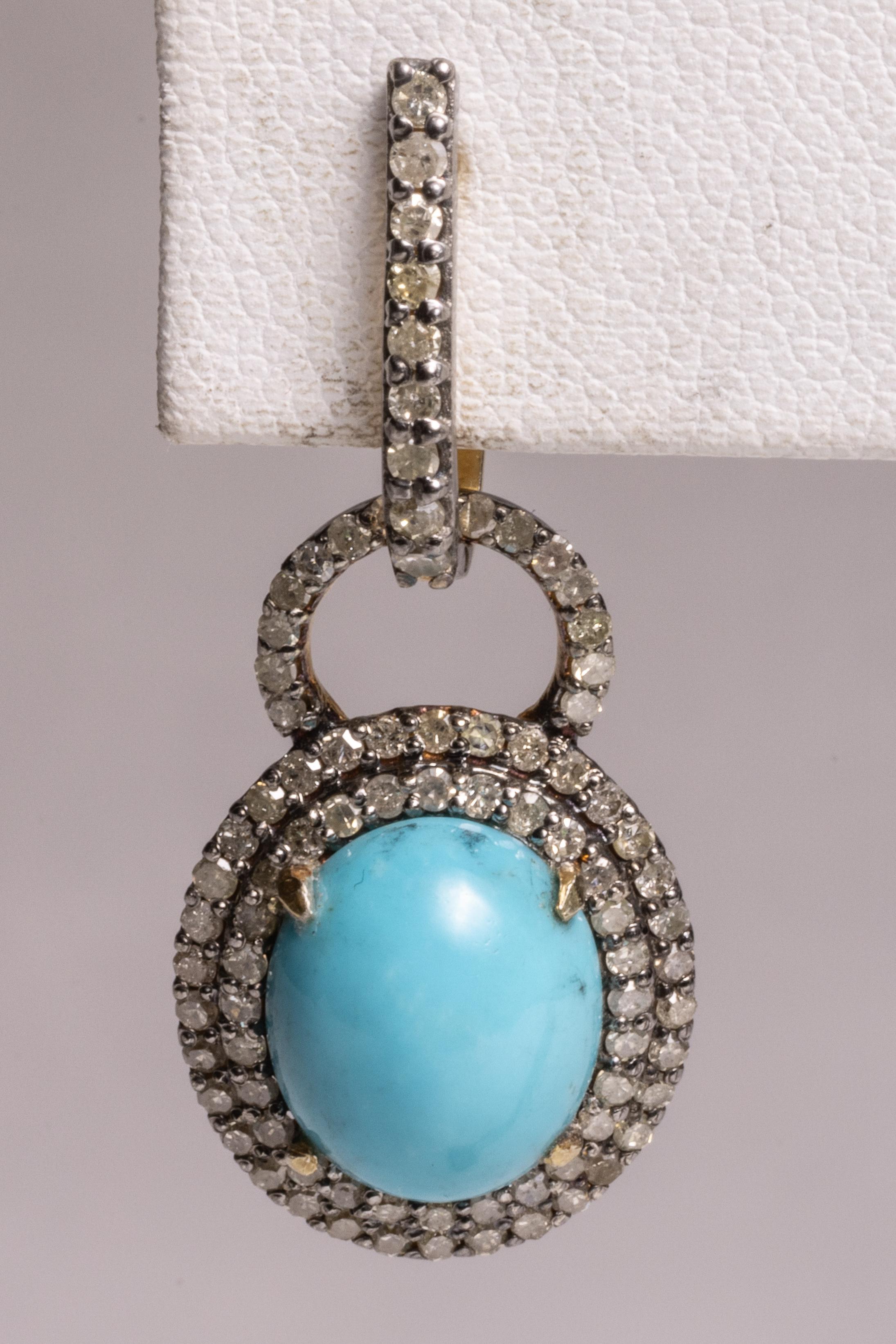 Highly desirable Sleeping Beauty turquoise in an oval cabochon cut.  Bordered with a double row of round, brilliant cut diamonds in a pave` setting.  French clip backs for pierced ears.  Diamonds total 1.60 carats and Turquoise is 5.59 carats.  Set