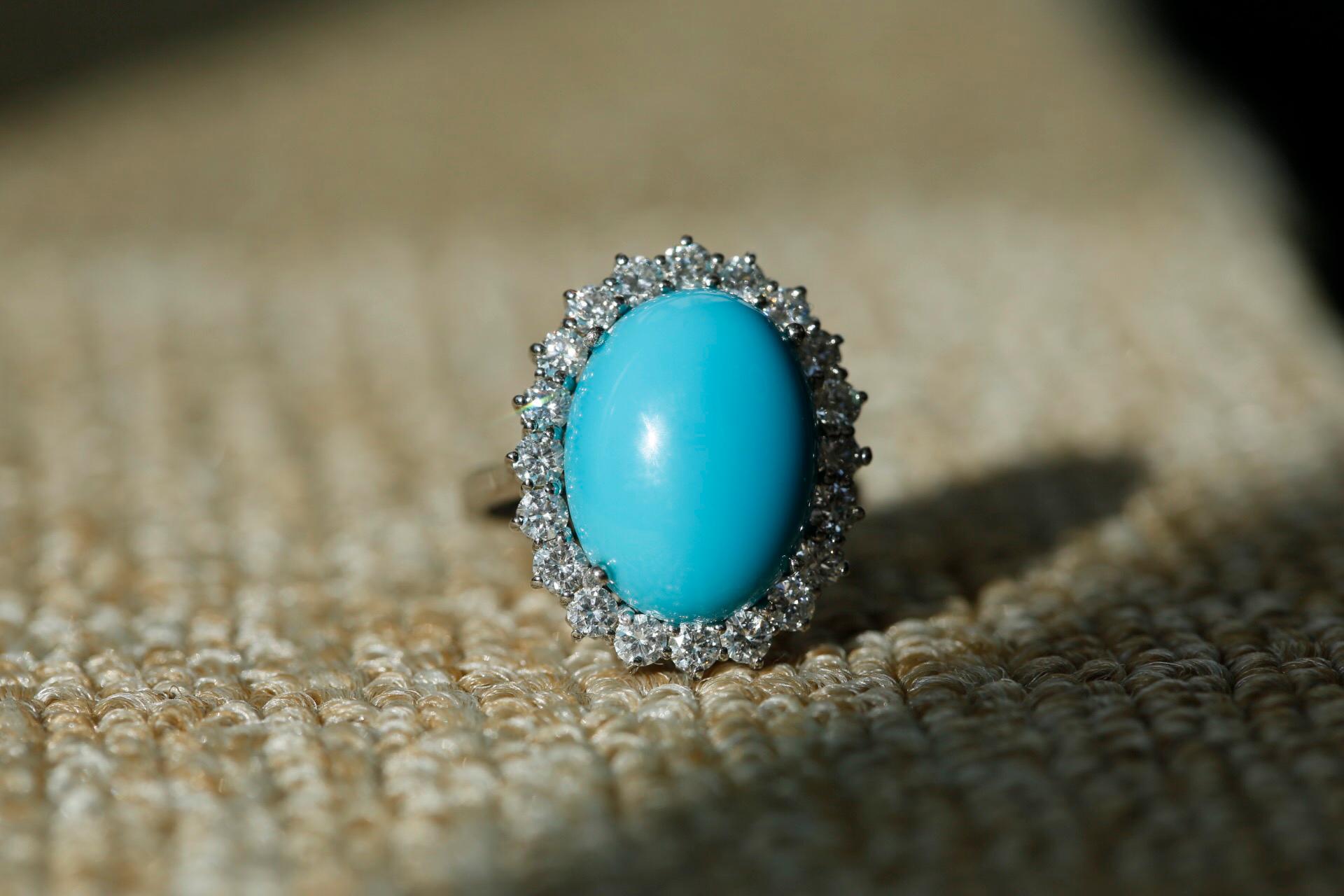 A captivating oval cabochon sleeping beauty turquoise enclosed by captivating bright and lively diamonds are all set in 18 karat white gold. This is the type of ring that you need to brighten up these dreary winter days; a delightful addition to any