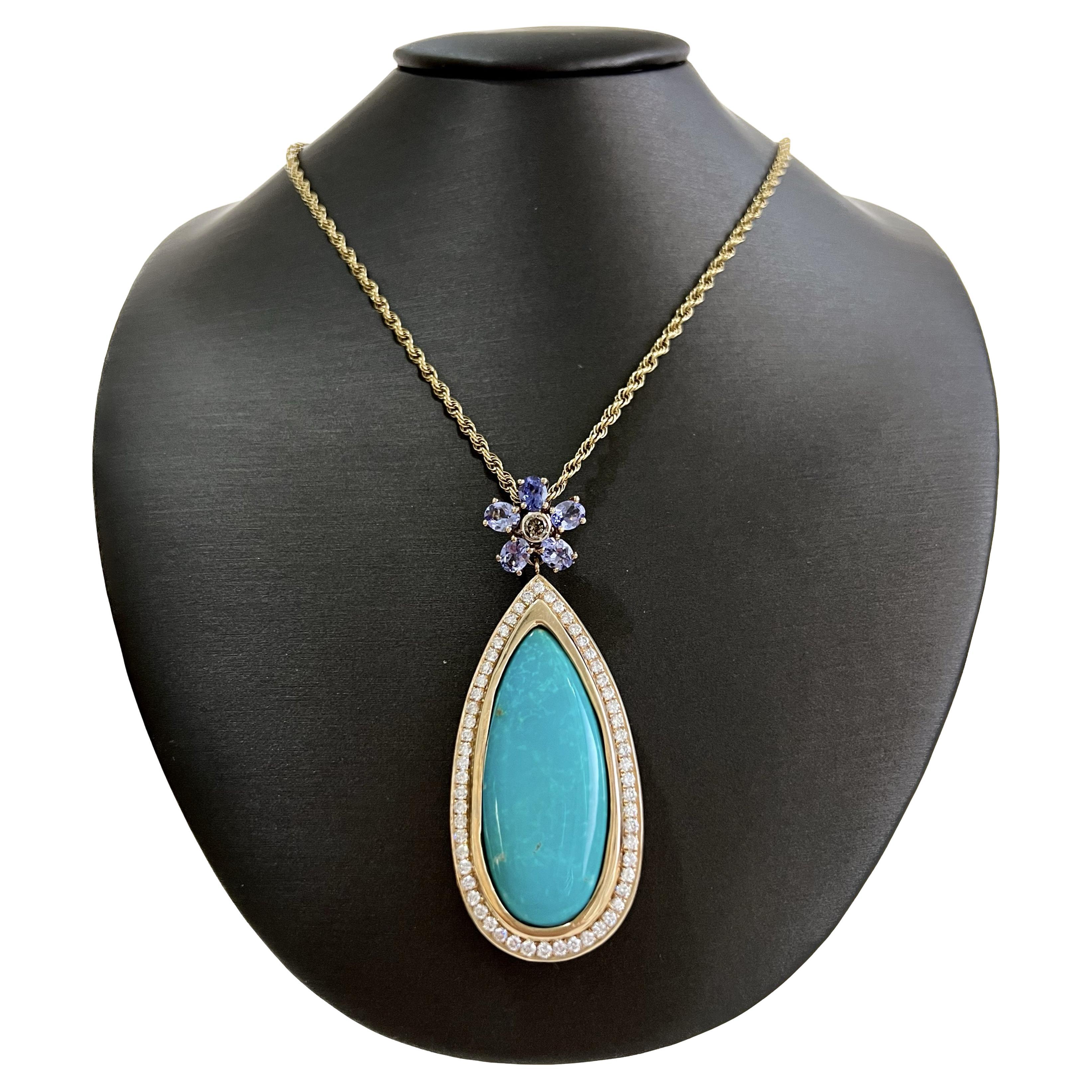 The gorgeous tear drop turquoise is the focal point in this handmade pendant.  The tanzanites form a flower top with a colored diamond bezel set that compliments the sleeping beauty turquoise that is be bezel set in a diamond frame.  The blue