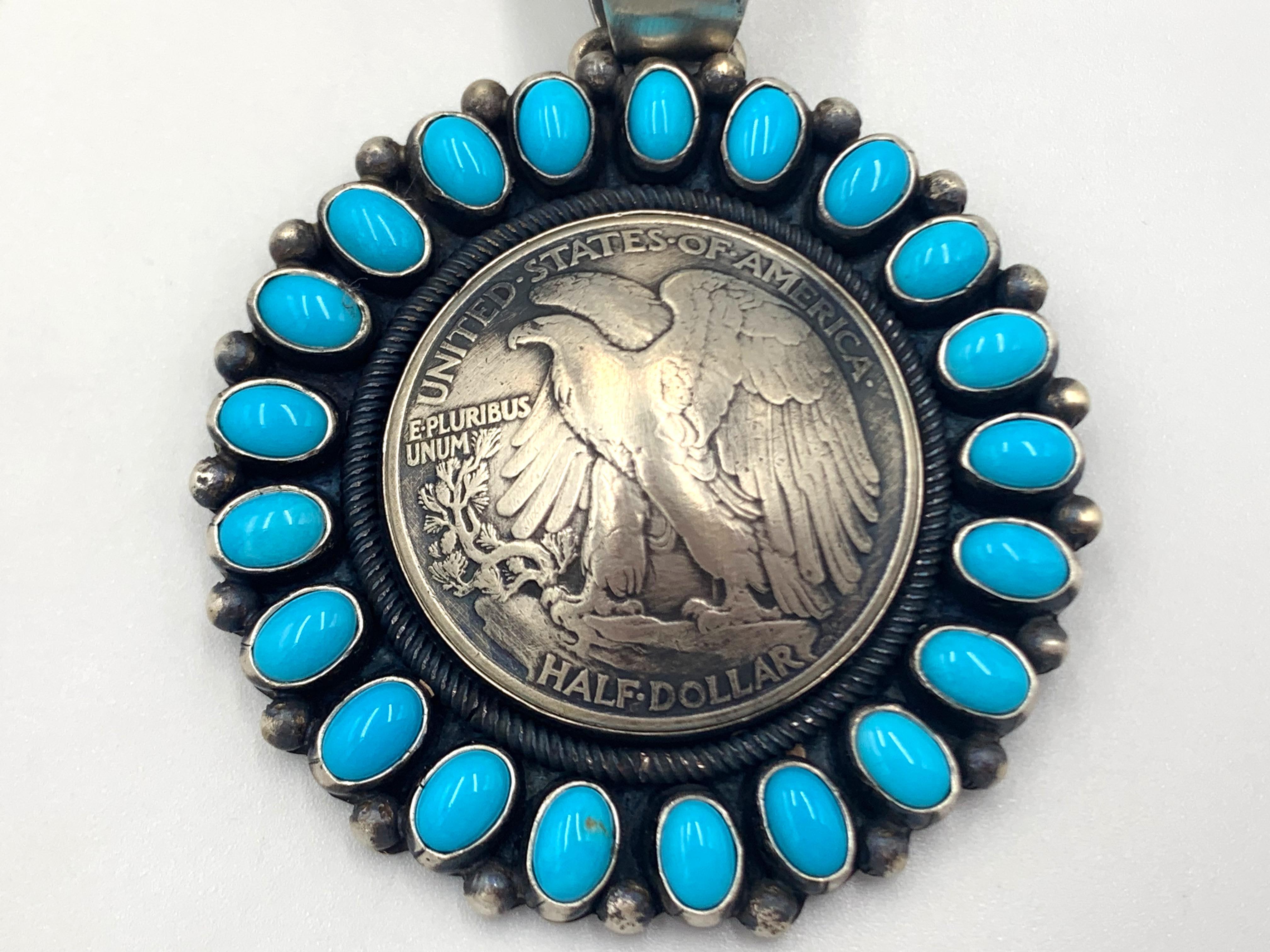 Sleeping beauty turquoise pendant with a silver half dollar centerpiece by Navajo silversmith Paul Livingston. The 2” X 2” pendant has 21 sleeping beauty turquoise cabochons showcasing a 1940s’ bald eagle half dollar. 

The Sleeping Beauty mine is