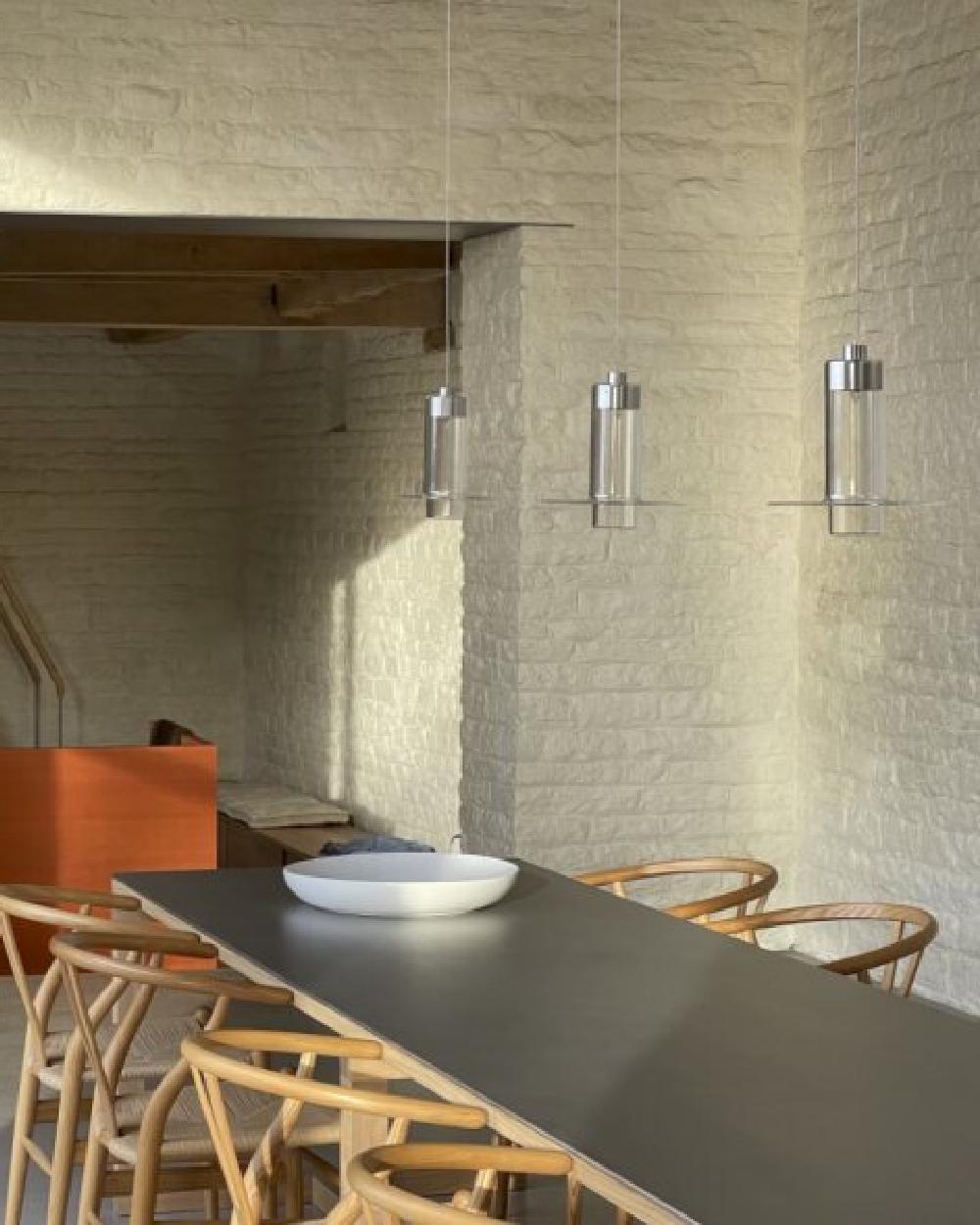 Il design di Pawson incastona perfettamente un cilindro di vetro fatto a mano all'interno di un altro, la cui parte esterna si svasa in un raffinato disco sul bordo inferiore. La lampada proietta la luce verso il basso, ma il suo corpo cristallino e