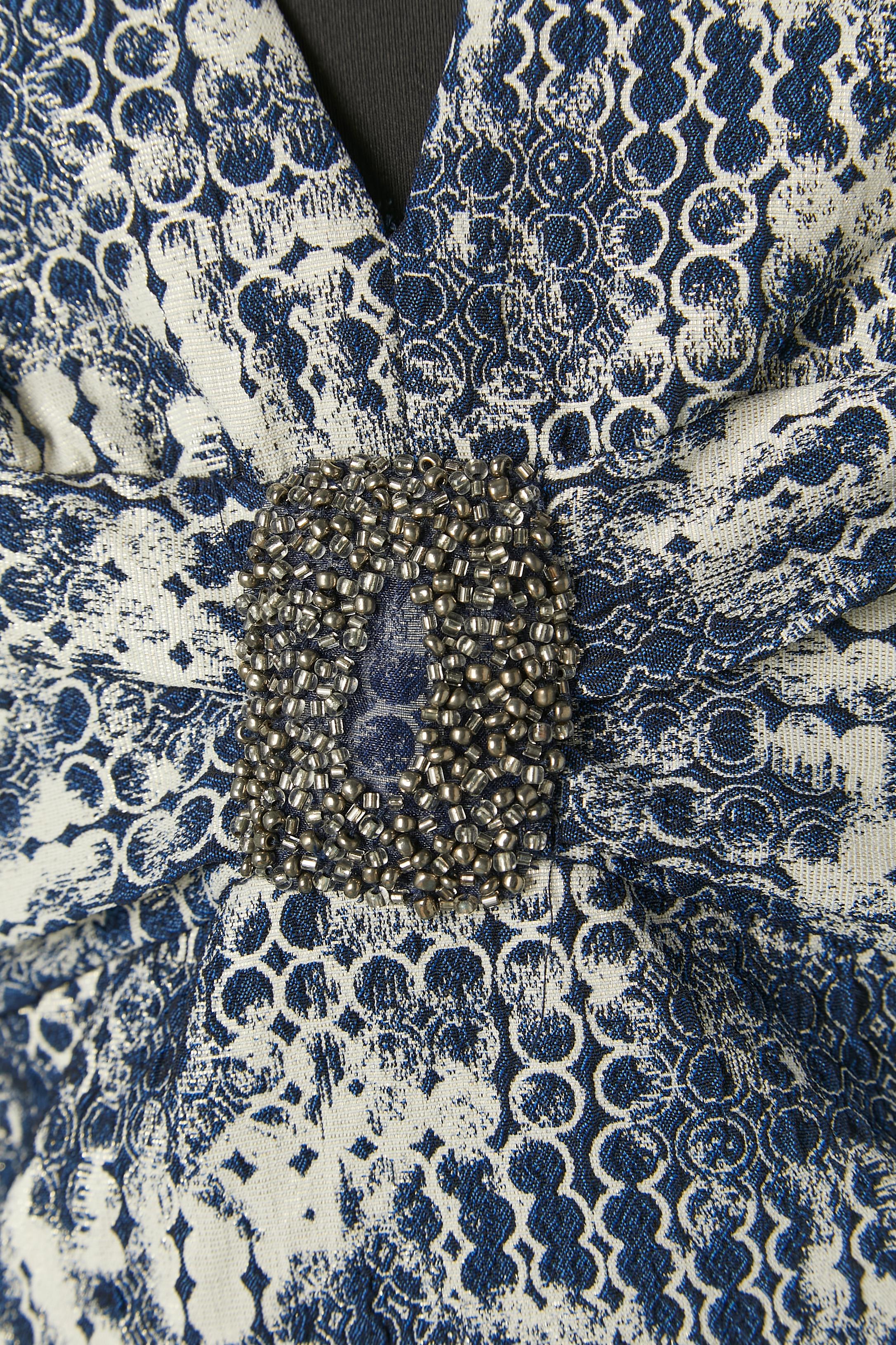 Sleeveless brocade cocktail dress with beadwork on the middle front.
Shell fabric composition: 86% polyester, 8% spandex, 6% metalic. Polyester lining.
Extra beads provided. 
Zip closure on the middle back + hook&eye. 
SIZE 10(US) L 
