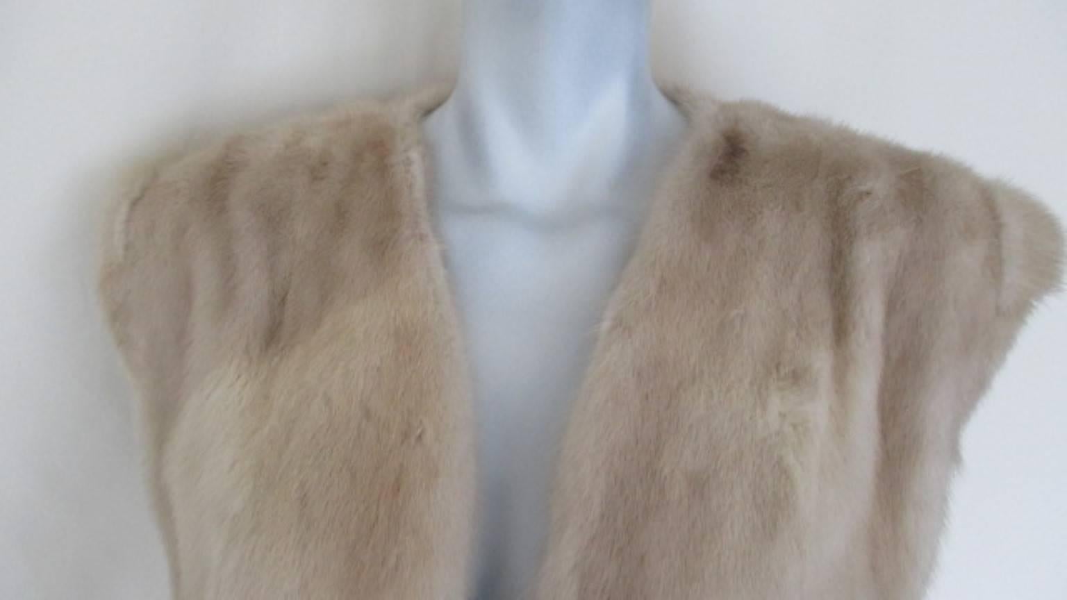 This light-weight mink vest has 2 pockets, 1 inside pocket and 3 leather fringe closing. 
Color:
Golden Pearl Mink is accentuated by a pale golden tone in its pearly coloured fur. Production volume is lower than the black and brown types of mink.