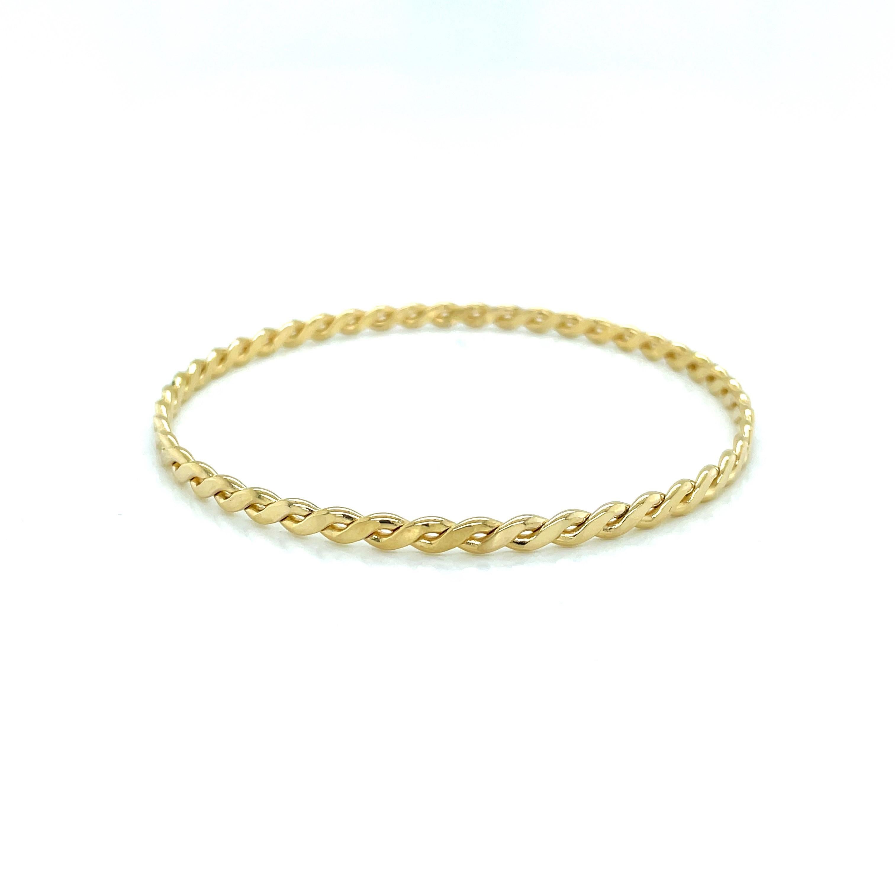 Slip on this classic bangle as the perfect accessory to compliment to your every day. In 14 karat yellow gold,  the braided rope twist design creates interest and youthful appeal.  Measures 2-5/8 inch with a 8 inch circumference (to determine the
