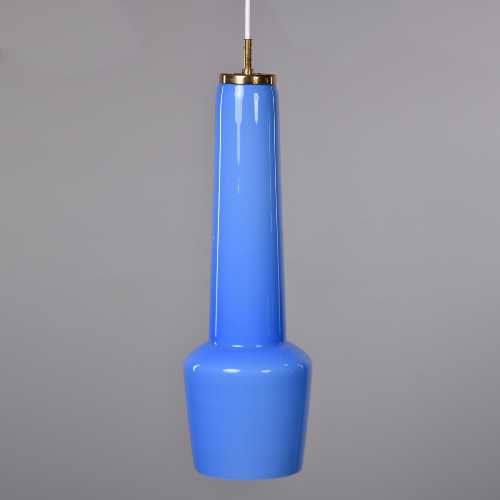 Found in Italy, this circa 1960 elongated glass pendant light by Stilnovo is a vibrant shade of periwinkle blue. Internal standard sized single socket has been rewired for US electrical standards. Brass canopy - top of fixture has manufacturer’s