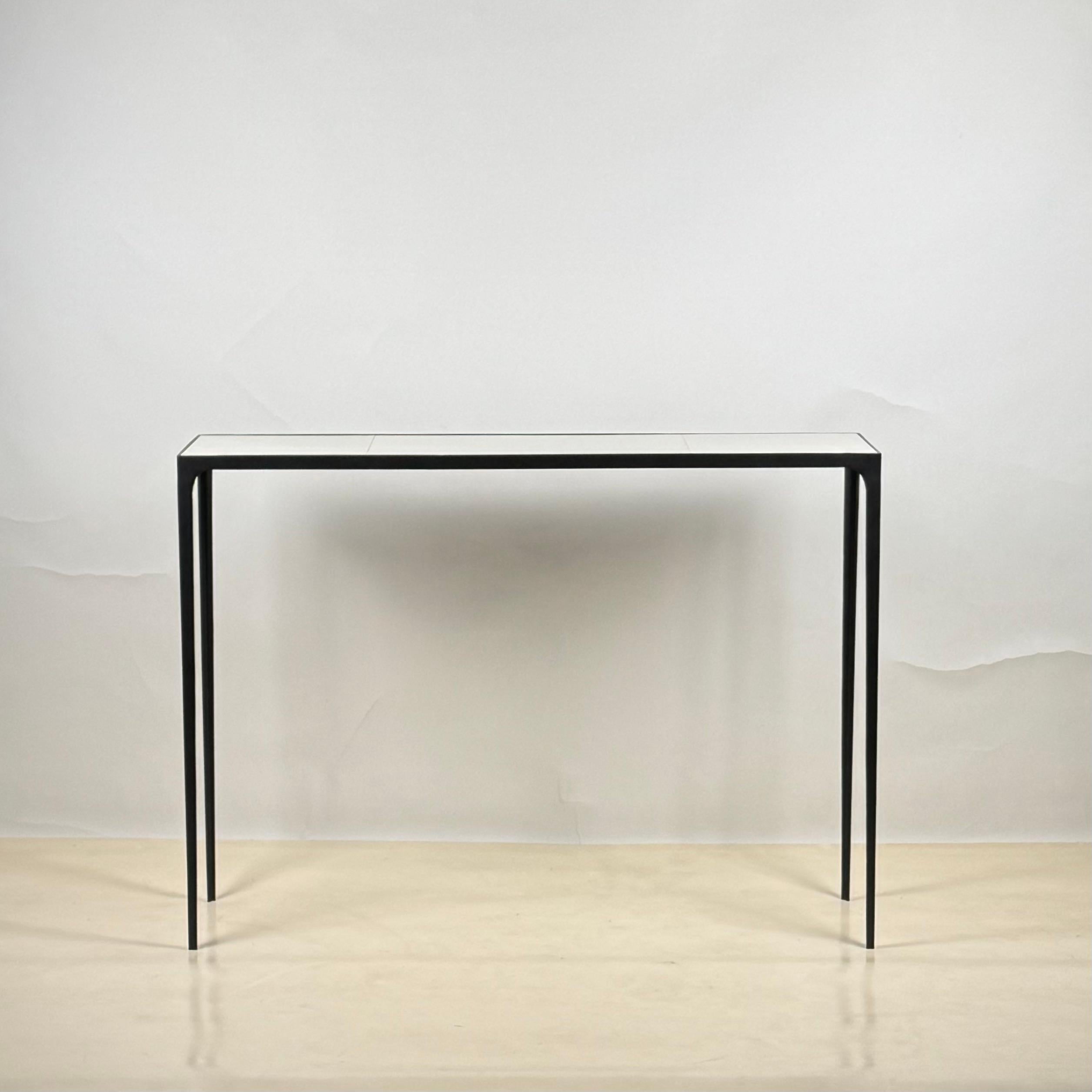Slender 'Esquisse' wrought iron and parchment console by Design Frères.
Chic combination of a slender blackened iron frame with an inset goatskin (parchment) clad top.
Balanced proportions. Understated elegance. Timeless.