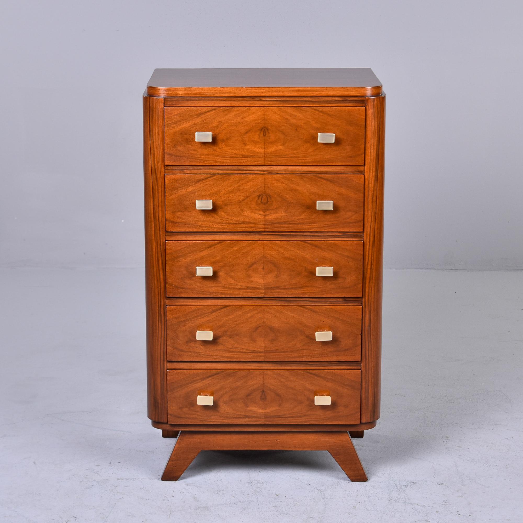 Found in France, this slender Art Deco five drawer chest dates from approximately 1940. We believe the wood to be mahogany, the original rectangular drawer pulls are brass and the front legs are angled out. Versatile size. We had this piece