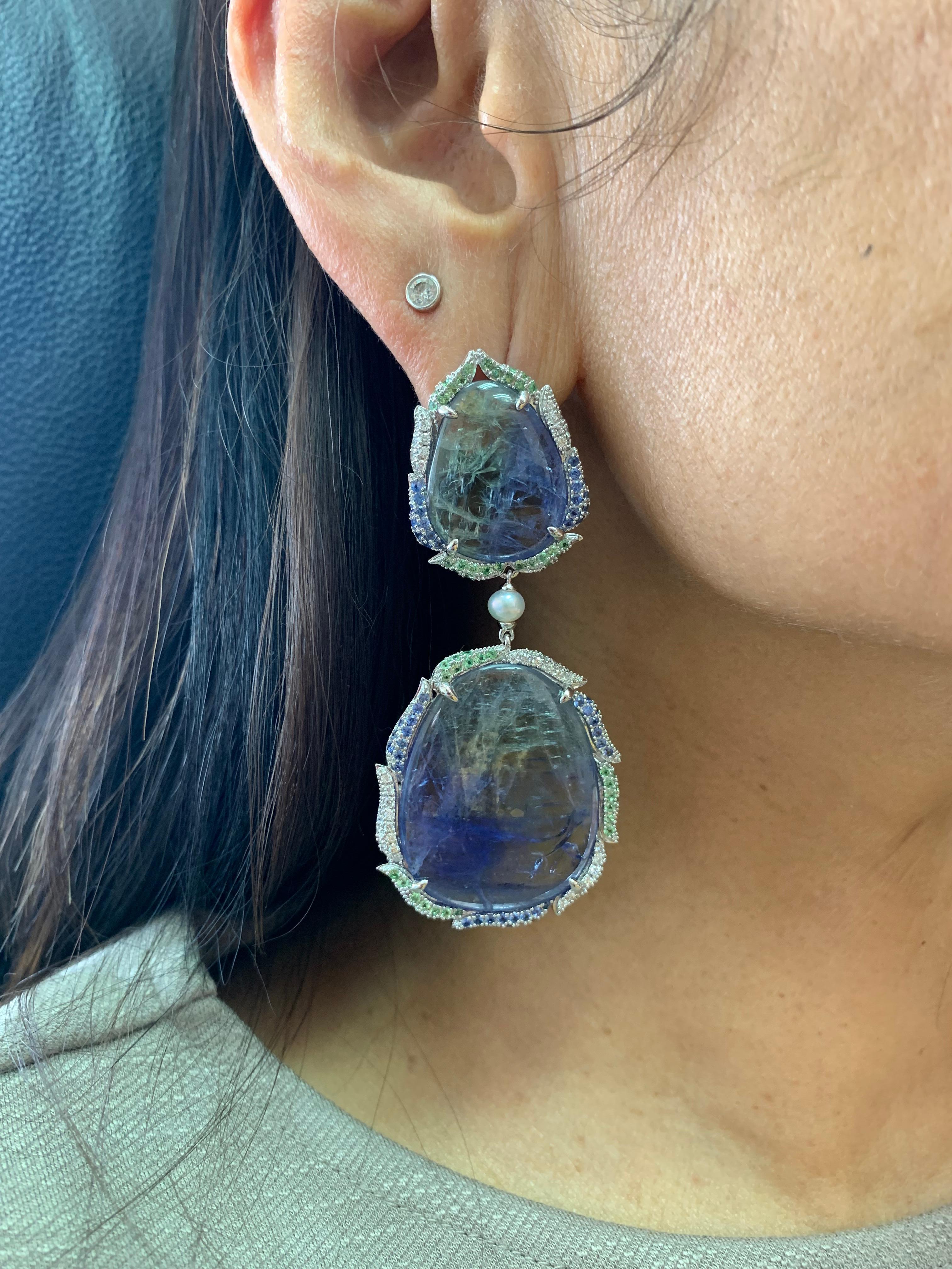 This is unique one-of-one earring incorporating sliced tanzanite with a nature inspired design using tsavorite and blue sapphire. 

Sliced Tanzanite Earrings with Gemstone & Diamond in 18 Karat White Gold

Tanzanite: 62.83  carats, fancy sliced