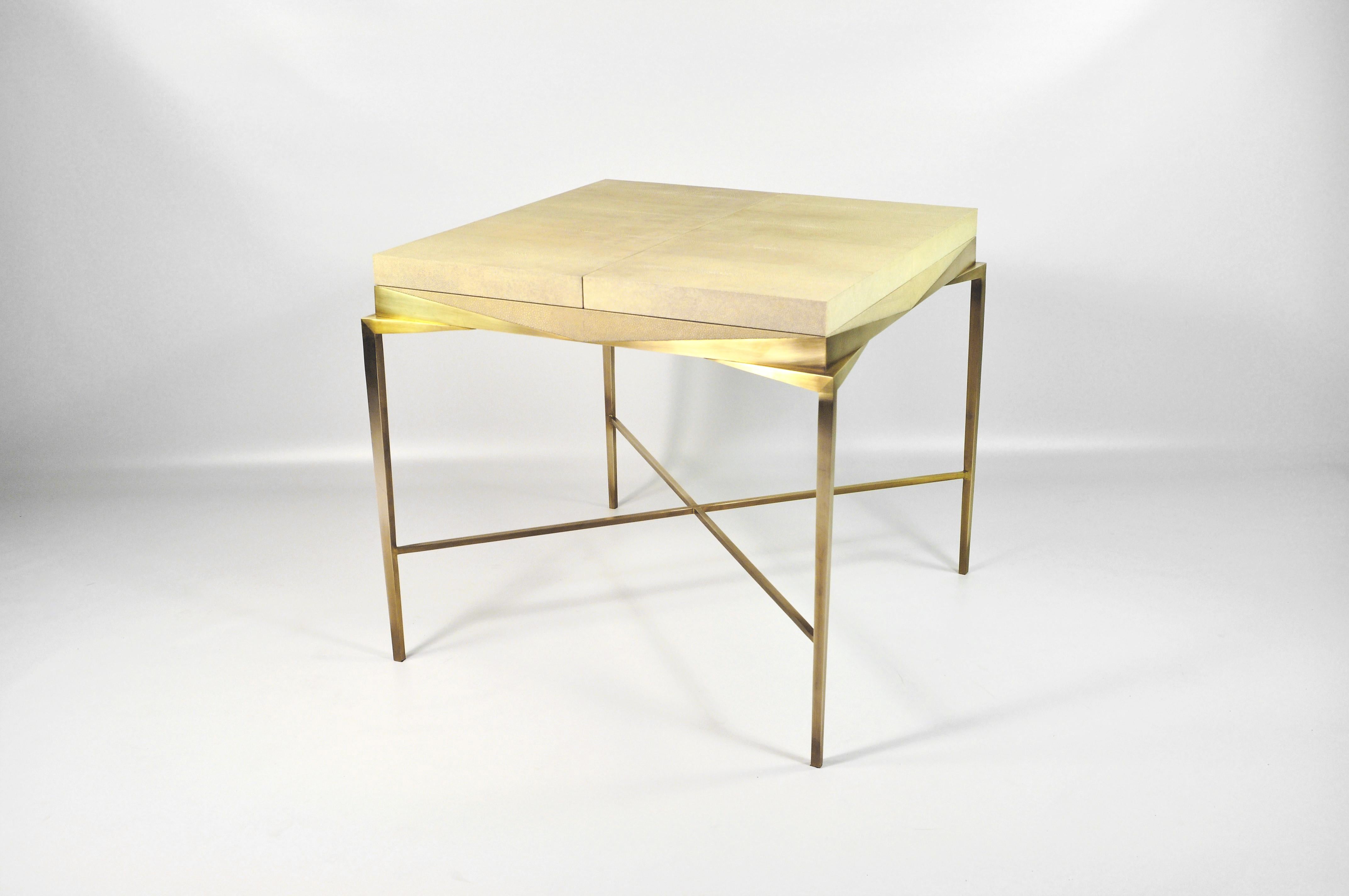 This square table is made for gamers.
It has a sliding top. When it's closed your can play cards and when it's opened you can play backgammon.
The top is made of shagreen, wood and brass. The legs are made of brass.
This piece when it's closed hide