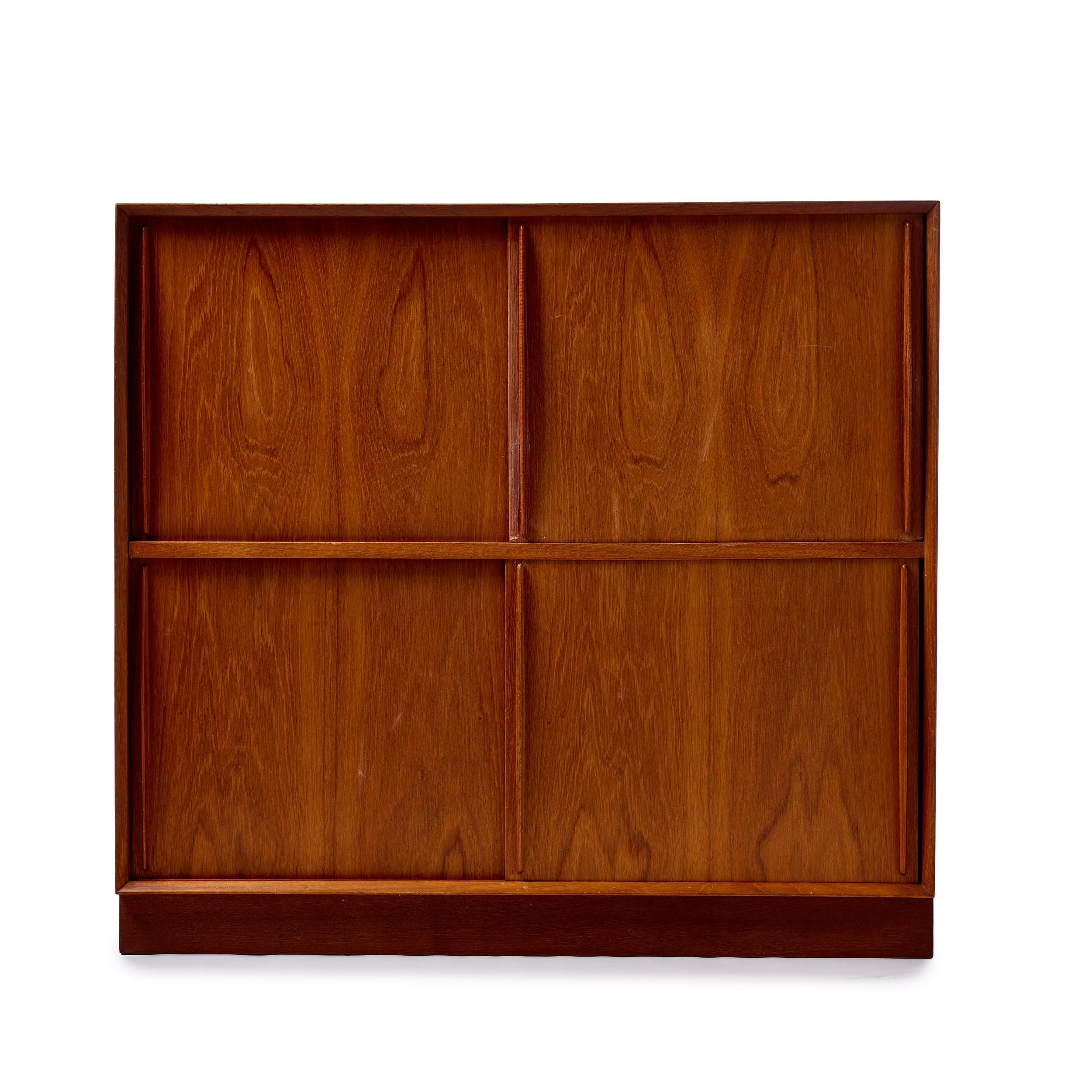 A Scandinavian modern modular cabinet by Peter Hvidt & Orla Mølgaard-Nielsen. Made of solid Burmese teak and features sliding doors, one fixed shelf and two adjustable shelves. Details offers beveled edge and finger jointed details.
Produced in