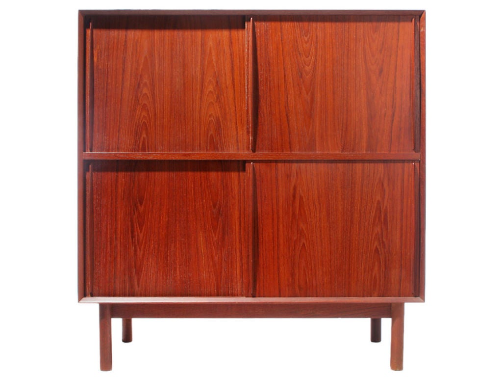 A Scandinavian modern modular cabinet by Peter Hvidt & Orla Mølgaard-Nielsen. Made of solid Burmese teak and features sliding doors, one fixed shelf and two adjustable shelves. Details offers beveled edge and finger jointed details.
Produced in