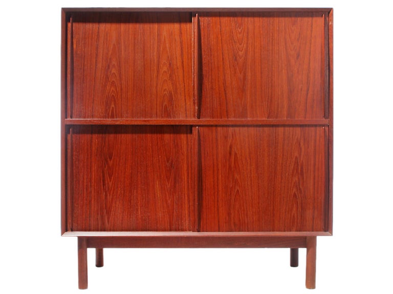 A Scandinavian modern modular cabinet by Peter Hvidt & Orla Mølgaard-Nielsen. Made of solid Burmese teak and features sliding doors, one fixed shelf and two adjustable shelves. Details offers beveled edge and finger jointed details.
Produced in