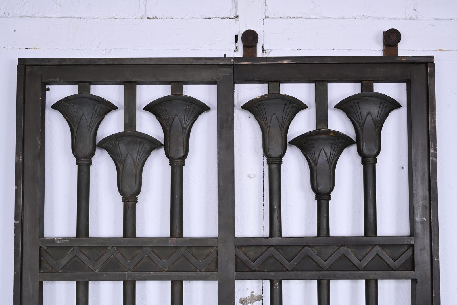 This sliding gate, adorned with Egyptian-inspired motifs, was created around 1880.

At the lower section, the panels are decorated with a geometric frieze of openwork X shapes. The verticality of the uprights is emphasized by stylized flowers with