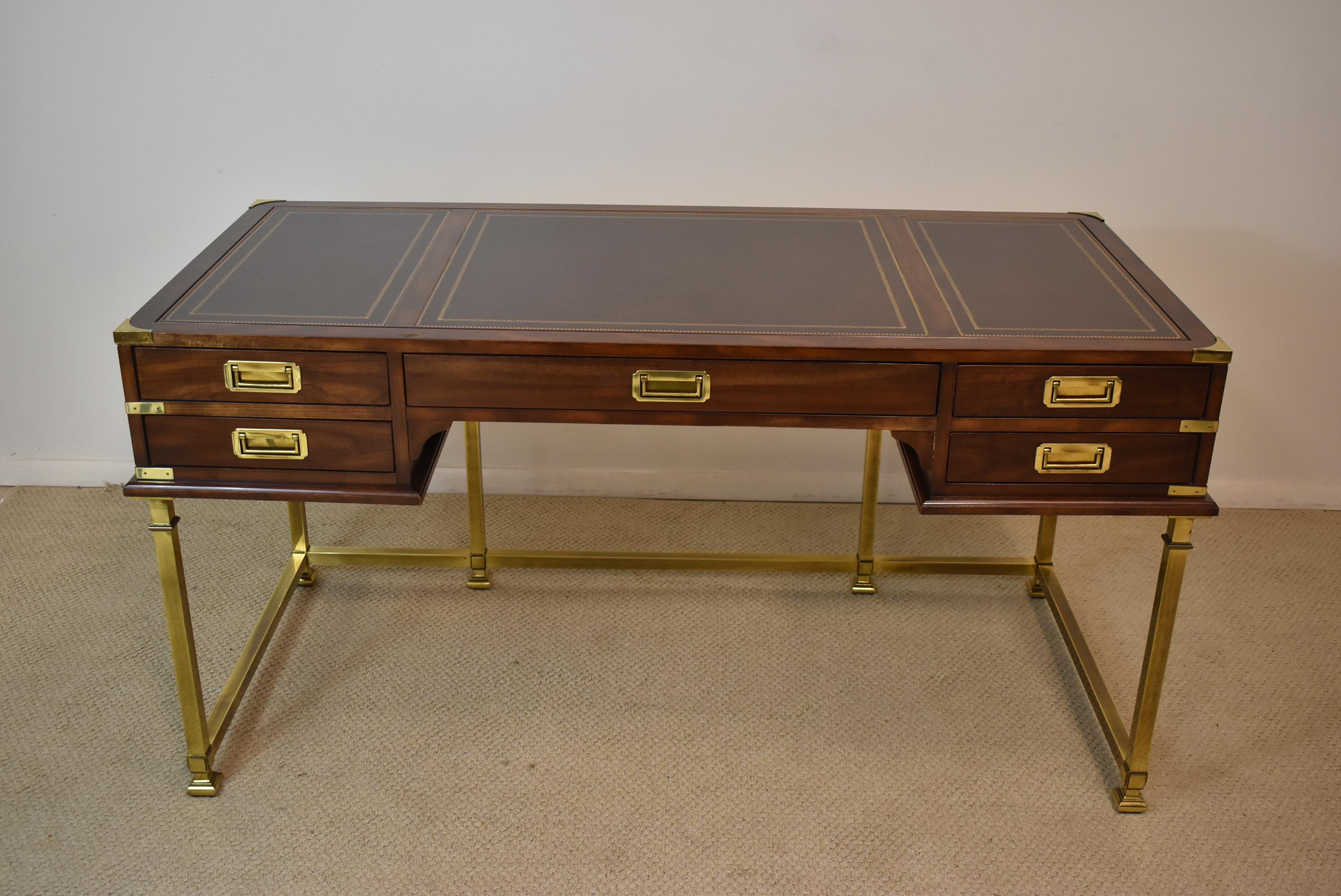Sligh campaign style desk in brass and cherry with a tooled leather top. Brass legs and corner brackets. Five dove tailed drawers. There is a custom piece that can be purchased in another listing as shown in last photo.