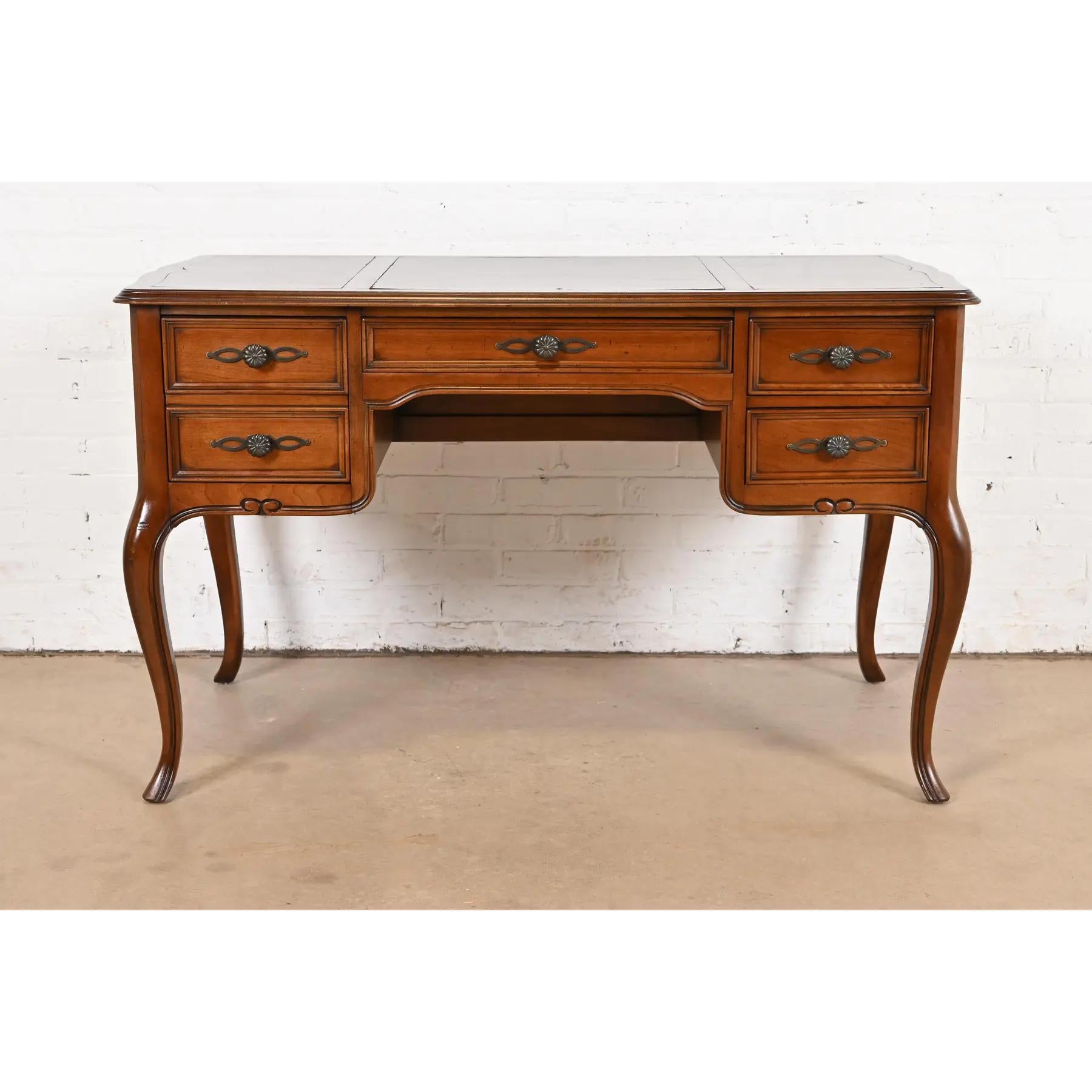 Un precioso escritorio o bureau plat de estilo Luis XV provincial francés

De Sligh Furniture

EE.UU., alrededor de 1960

Madera maciza de cerezo tallada, con tapa de cuero repujado y herrajes originales de latón.

Medidas: 48