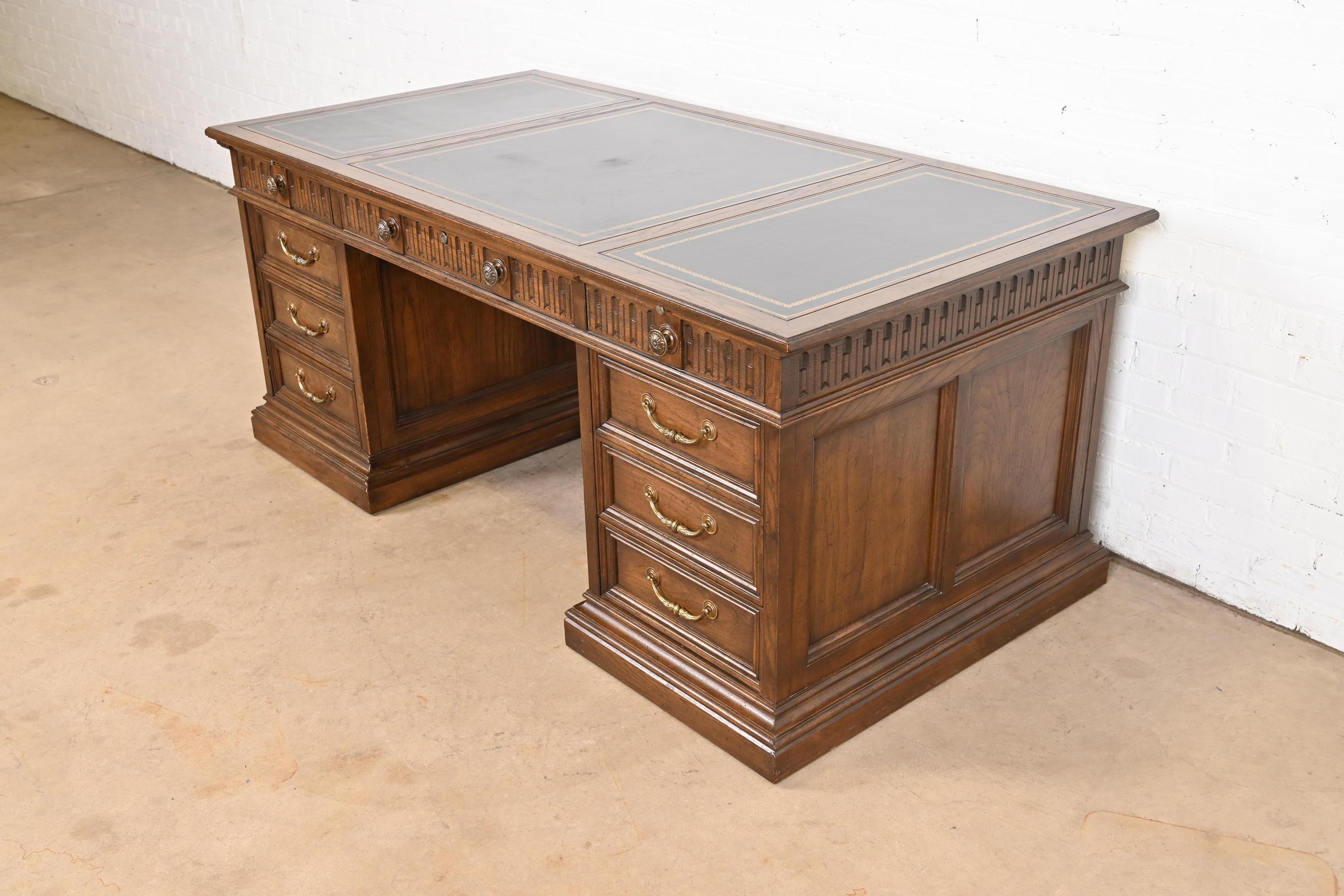 A gorgeous Regency style executive desk.

By Sligh Furniture

USA, Circa 1960s

Carved oak, with embossed leather top, and original brass hardware. Middle drawer locks, and key is present.

Measures: 72