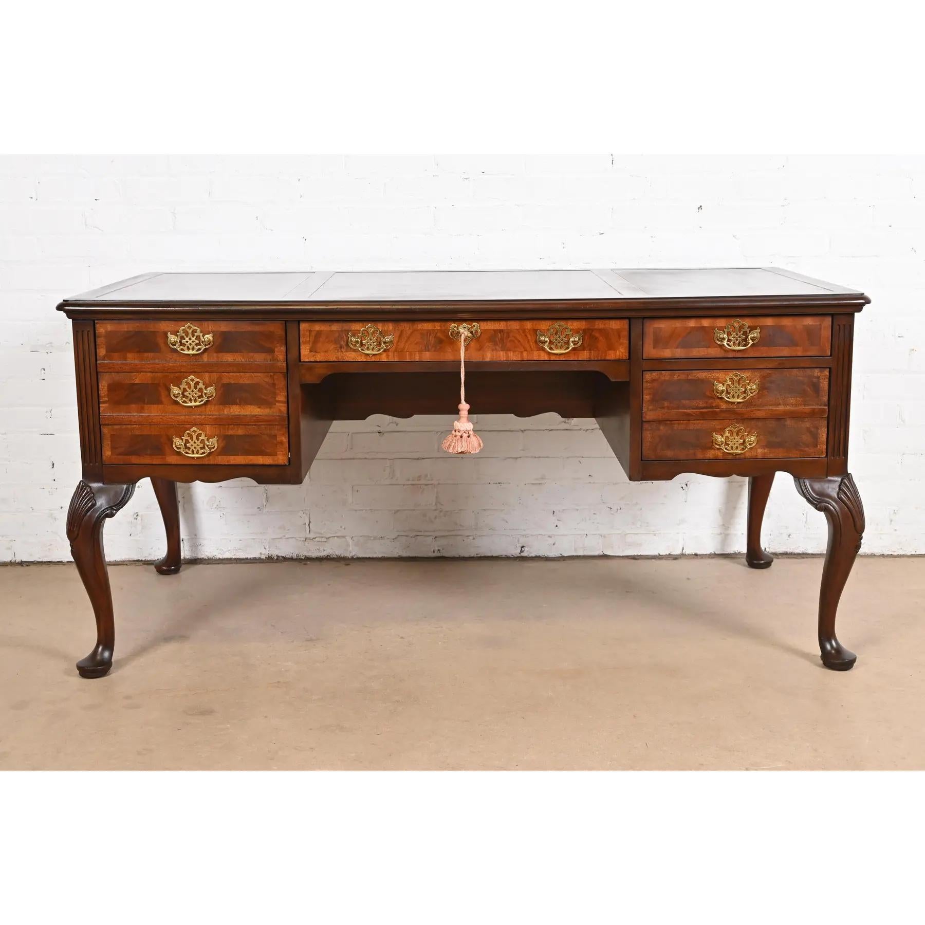 An exceptional Georgian or Queen Anne style executive writing desk

By Sligh Furniture

USA, Circa 1980s

Flame mahogany, with satinwood banding, embossed leather top, and original brass hardware. Middle drawer locks, and key is included.

Measures: