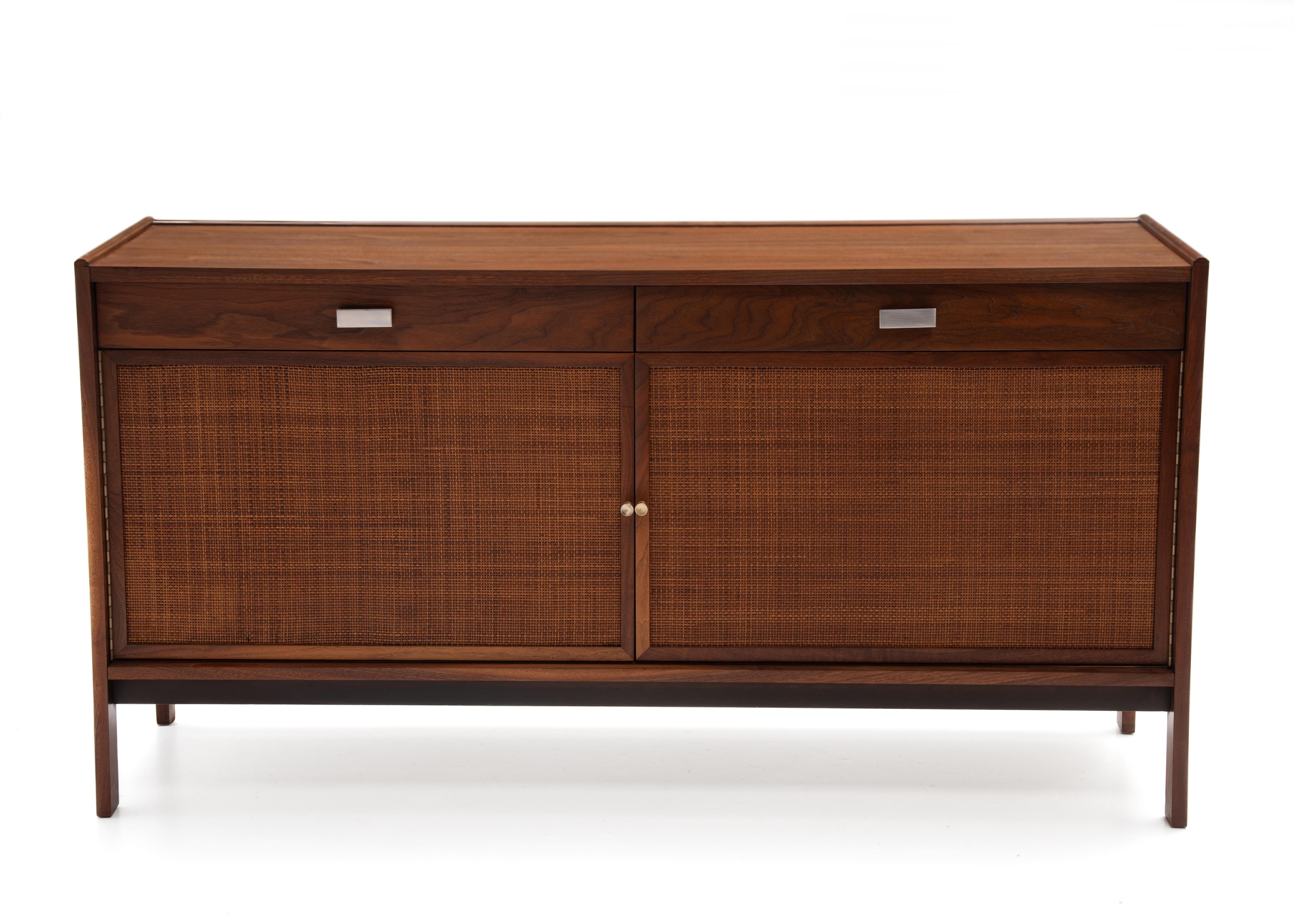 Crédence du milieu du siècle en noyer et en rotin fabriquée par Sligh Lowry furniture of Holland, Michigan. Noyer massif et placage de noyer avec portes cannées, charnières piano en laiton sur les portes, tirettes en laiton et poignées chromées. Les