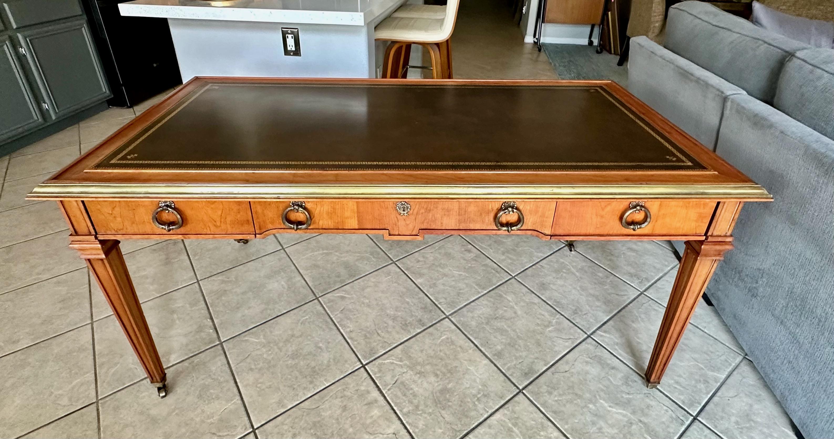 Scrivania vintage di Sligh Furniture. Realizzato in mogano con bordi in ottone, piano in pelle lavorata a mano con chiave greca, fleur de lis, picche ripetute e tiretti neoclassici, rotelle in ottone a riposo. Rifinito di recente con finitura noce