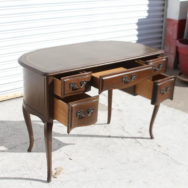 Scrivania curvilinea in noce Sligh con piano in pelle
Elegante e intramontabile tavolo da scrittura a cinque cassetti con piano in noce e pelle marrone lavorata. Gambe a cabriole, fondo e cassetti centrali smerlati e grembiule curvo. Tiraggi in
