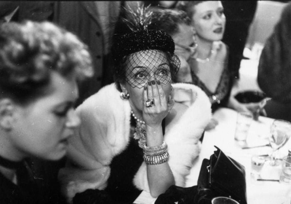 An Anxious Wait 
1951
by Slim Aarons

Slim Aarons Limited Estate Edition

2nd April 1951: American actress, Gloria Swanson, anxiously awaits the results of the Best Actress award at a cafe on West 52nd Street, New York. On her left is her fellow