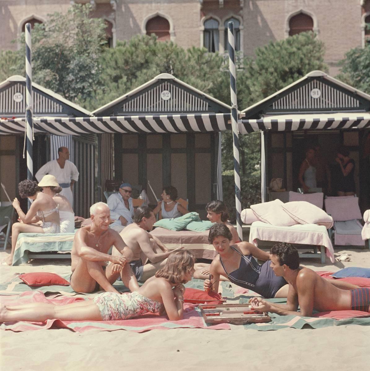 Slim Aarons Color Photograph - Backgammon on the beach at Biarritz, France