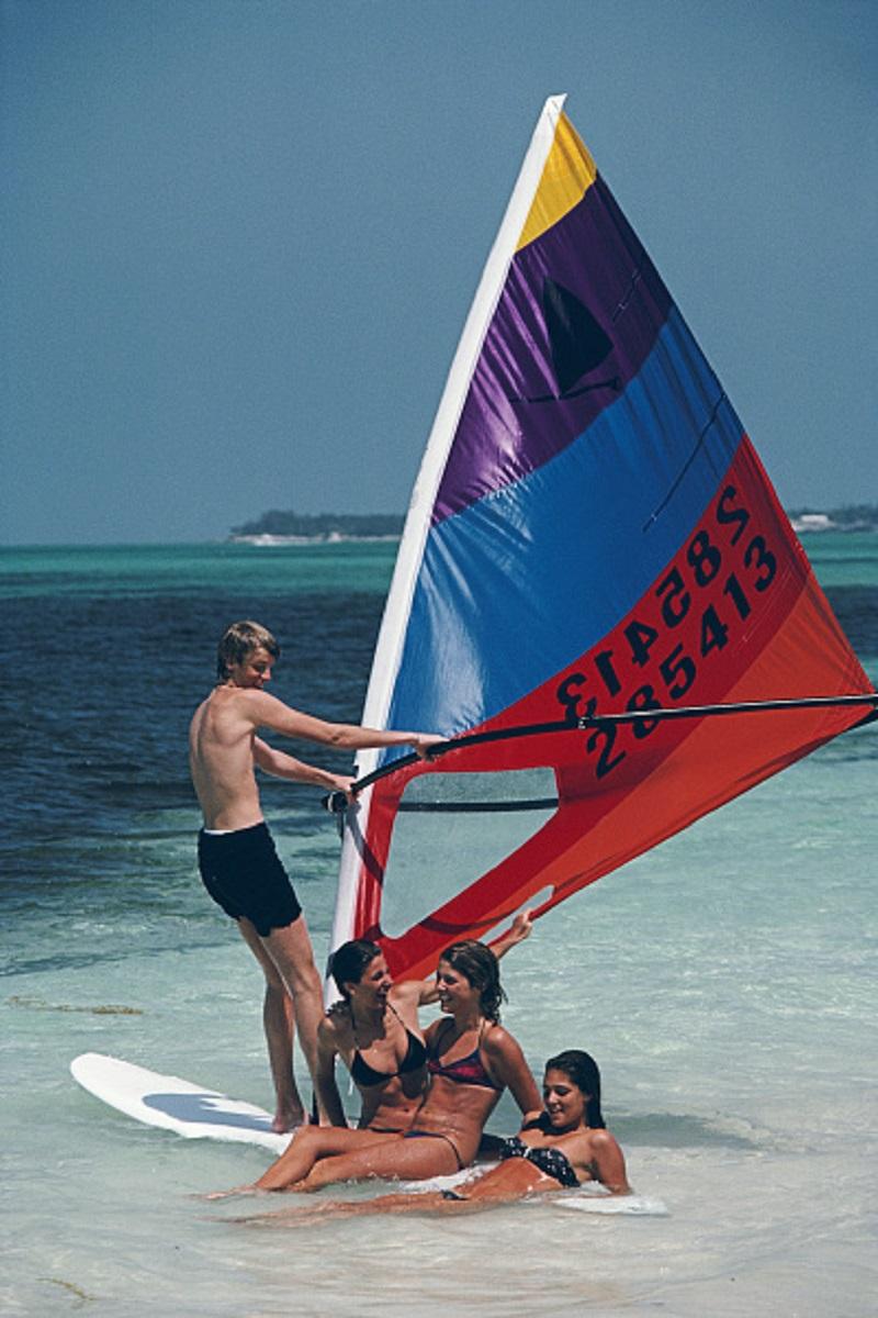 'Bahamas Windsurfing' 1983 Slim Aarons Edición Limitada Estate Print 

Haciendo windsurf en Lyford Cay, Bahamas, abril de 1983.

Producido a partir de la transparencia original
Certificado de autenticidad suministrado 
Archivo sellado

Tamaño del