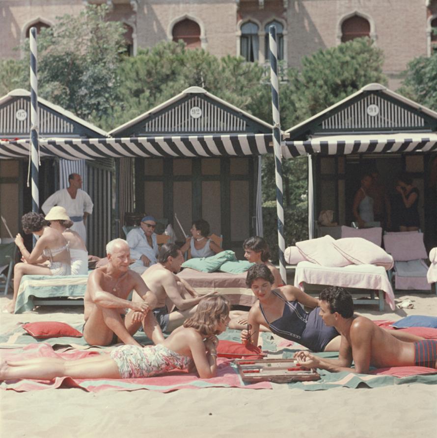 Beach Backgammon 
1957
by Slim Aarons

Slim Aarons Limited Estate Edition

Backgammon on the beach at the Hotel Excelsior on the Venice Lido, Italy, 1957. 




unframed
c type print
printed 2023
16 × 16 inches - paper size


Limited to 150 prints