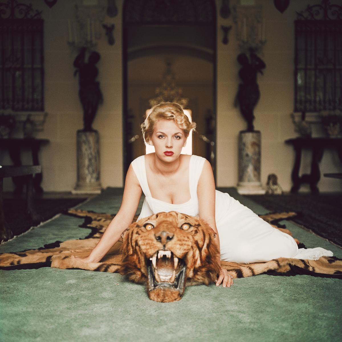 Beauty and the Beast 

1959

Lady Daphne Cameron (Mrs George Cameron) on a tiger skin rug in the trophy room at socialite Laddie Sanford’s home in Palm Beach, Florida.

Photo by Slim Aarons

12 x 12” / 30 x 30 cm paper size 
Archival pigment