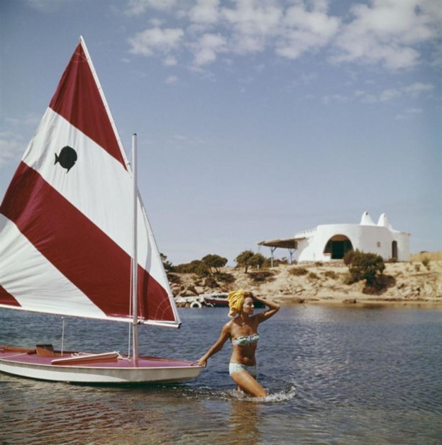 Bettina Graziani 
1964
by Slim Aarons

Slim Aarons Limited Estate Edition

French fashion model Bettina Graziani wading in the shallow waters of Costa Smeralda, pulling a small yacht behind her, in Sardinia, Italy, 1964.

unframed
c type