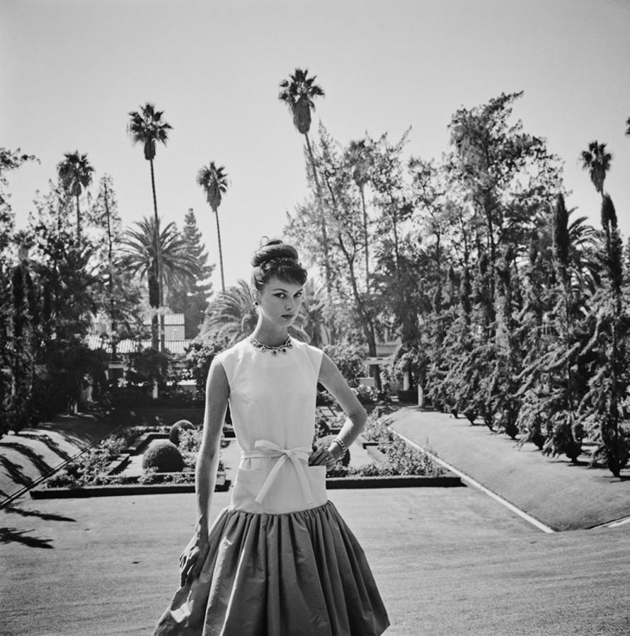 Beverly Hills Model 
1960
by Slim Aarons

Slim Aarons Limited Estate Edition

Model Gretchen Van de Kamp Ward wearing a dinner dress by Gustave Tassell, Beverly Hills, 1960. The bodice is made of white silk faille and the skirt is apple green peau