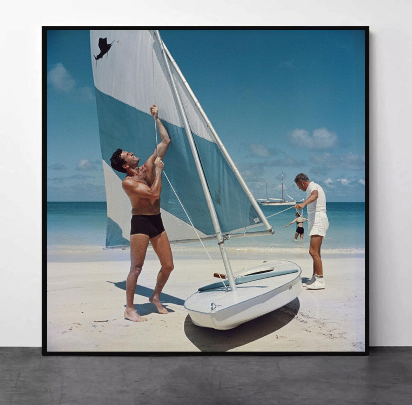 Slim Aarons
Boating In Antigua
1961 (printed later)
C print
Estate stamped and numbered edition of 150 
with Certificate of authenticity
Caption: American actor Hugh O'Brian (left) hoists the sail on a dinghy, Antigua, West Indies, 1961. (Photo by