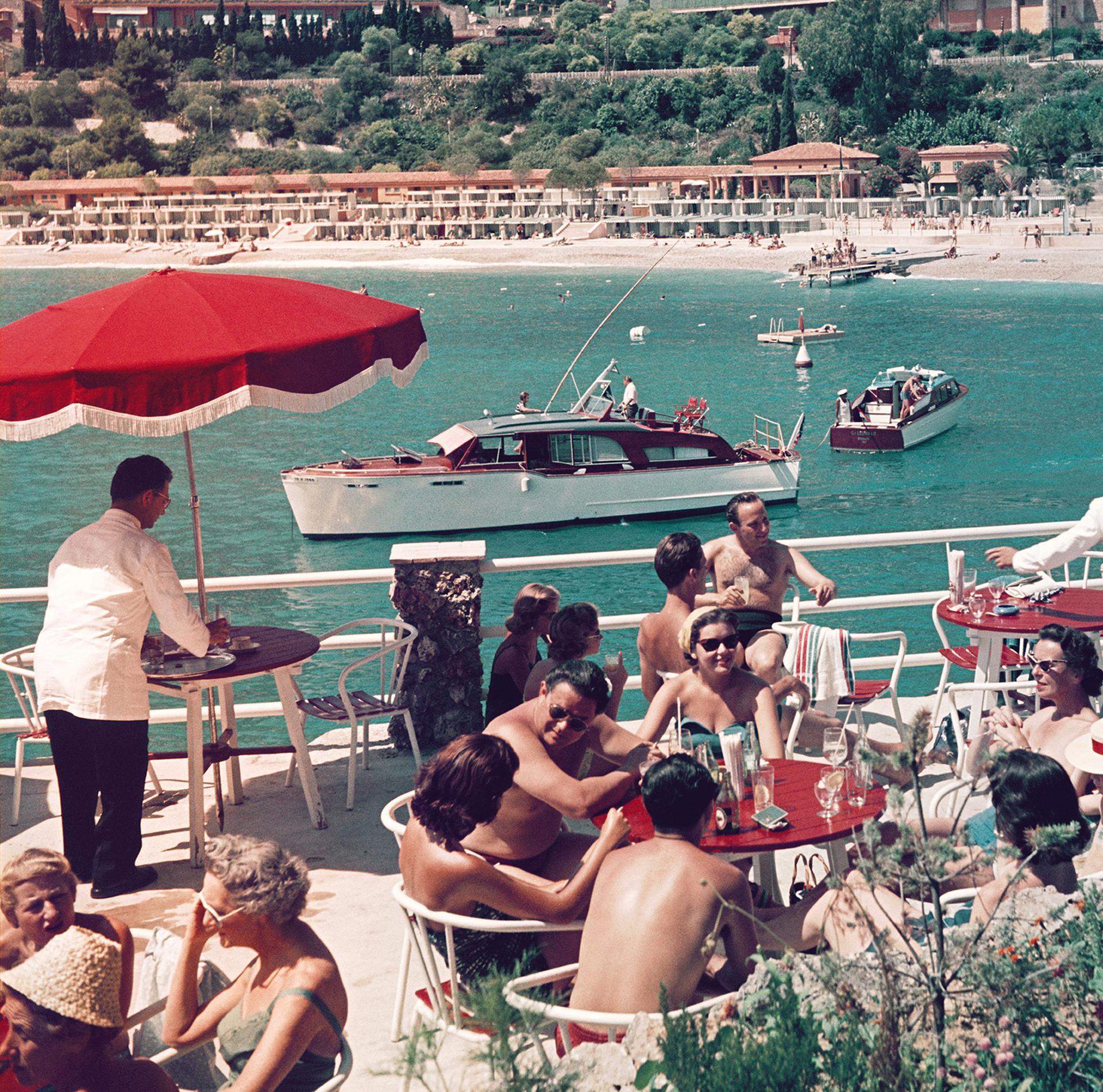 Esta fotografía de paisaje de finales de los años 50, captada por el fotógrafo de sociedad Slim Aarons, muestra a unos veraneantes en la terraza de un café de Niza, en la Costa Azul francesa.

Se trata de una edición sellada y numerada a mano de 150