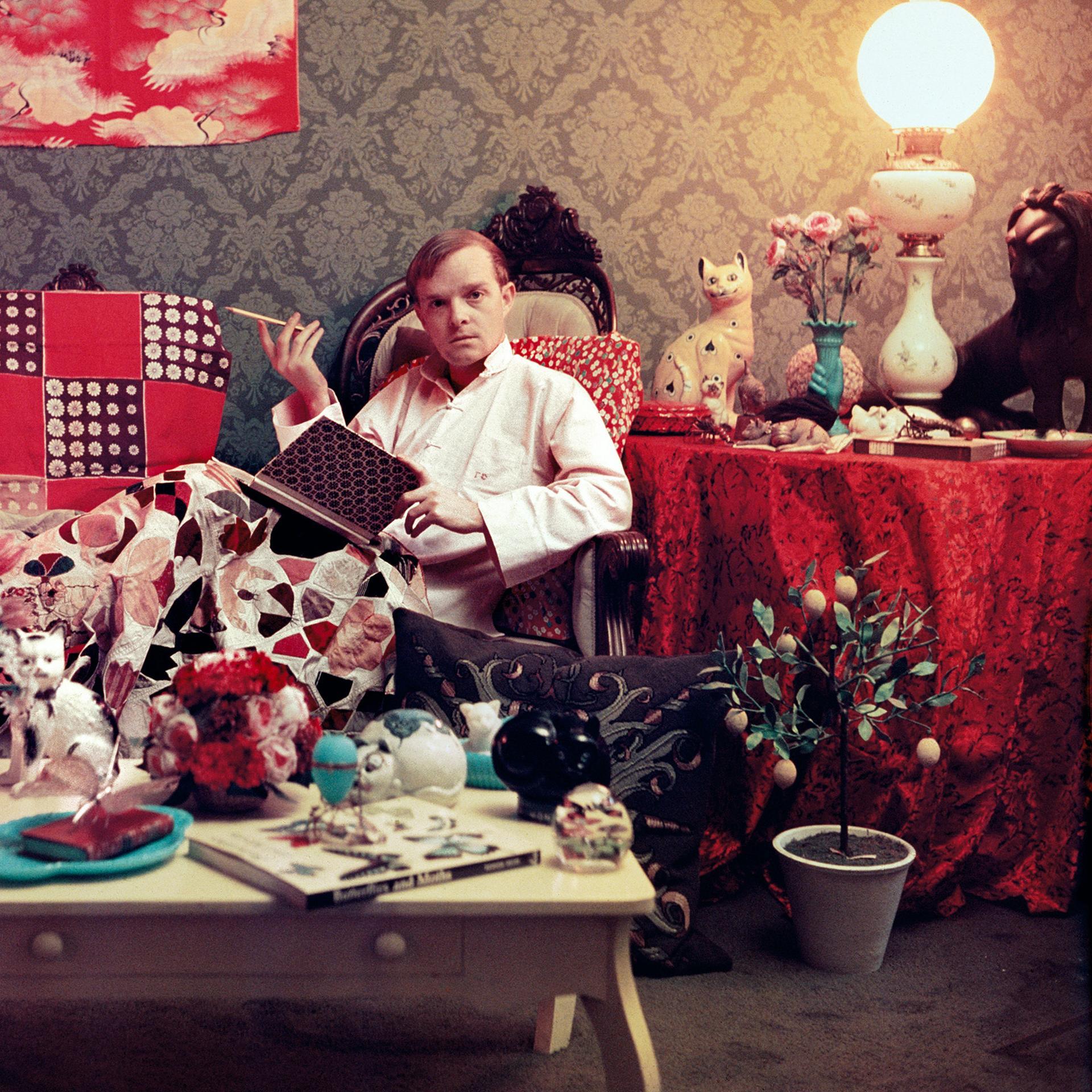 Dieses Porträtfoto des Society-Fotografen Slim Aarons aus den späten 1950er Jahren zeigt den Schriftsteller Truman Capote (1924-1984), der sich mit einem Buch und einer Zigarette in seiner unaufgeräumten Wohnung in Brooklyn Heights, New York,