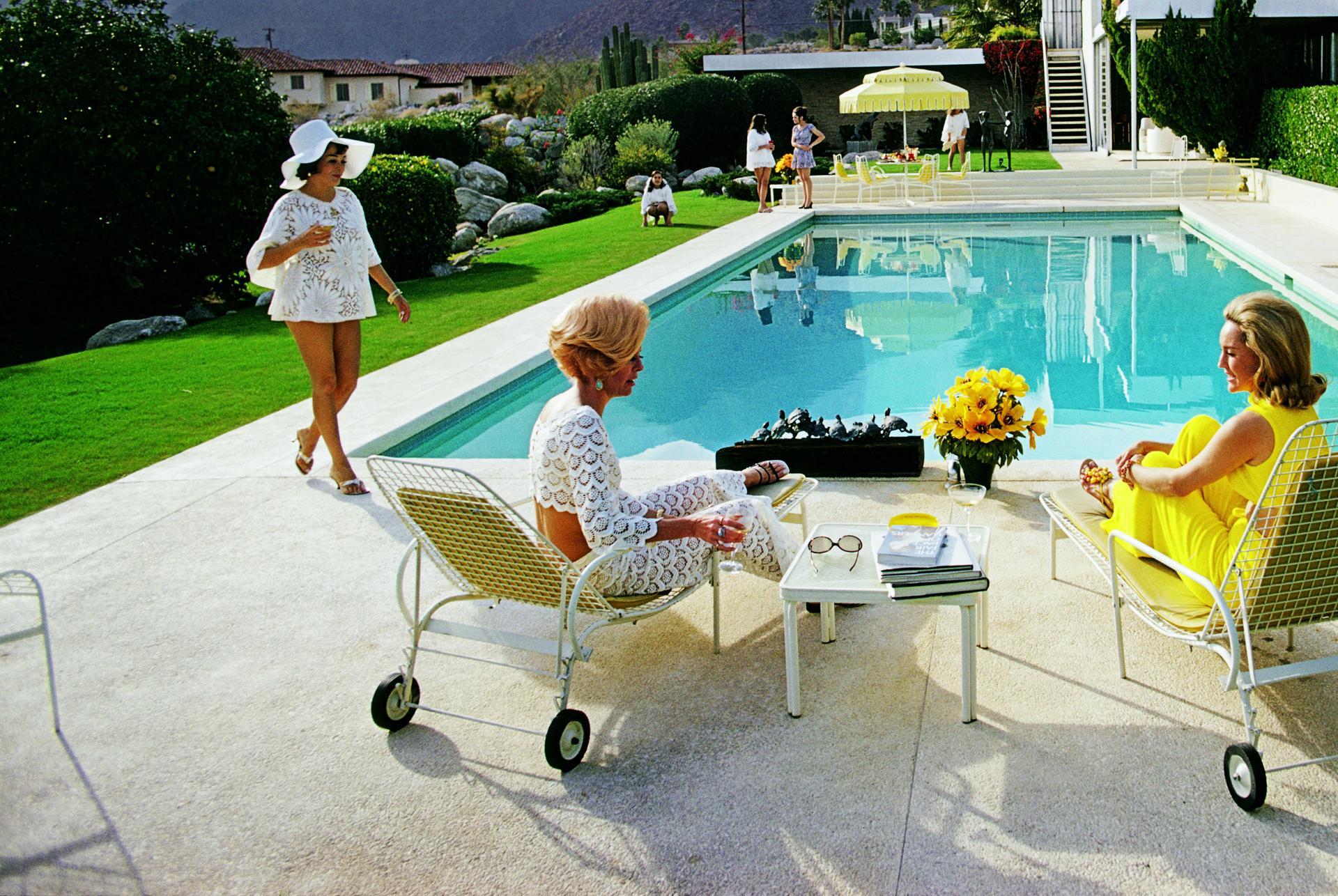Palm Springs, 1970: Dieses begehrte Foto des Society-Fotografen Slim Aarons zeigt Prominente aus der Mitte des Jahrhunderts vor dem türkisfarbenen Swimmingpool des berühmten Kaufmann Desert House, das 1954 vom Architekten Richard Neutra entworfen