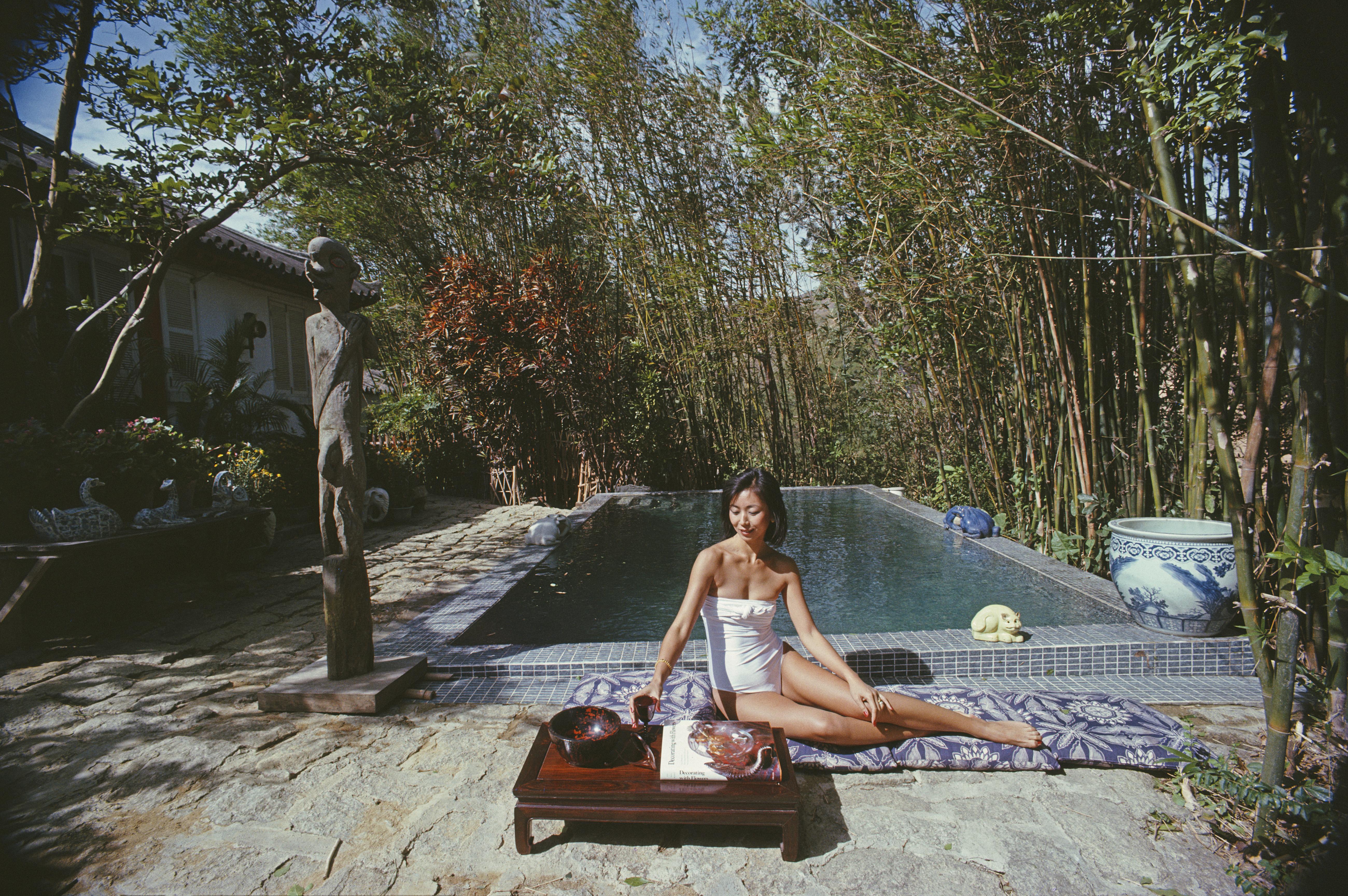 'Cecily Godfrey' 1979 Slim Aarons Limited Estate Edition Print 

Cecily Godfrey relaxes by the pool at her home in Hong Kong, 1979. Her husband Gerald is Vice-President of the Court of Appeal in Hong Kong. 

Produced from the original