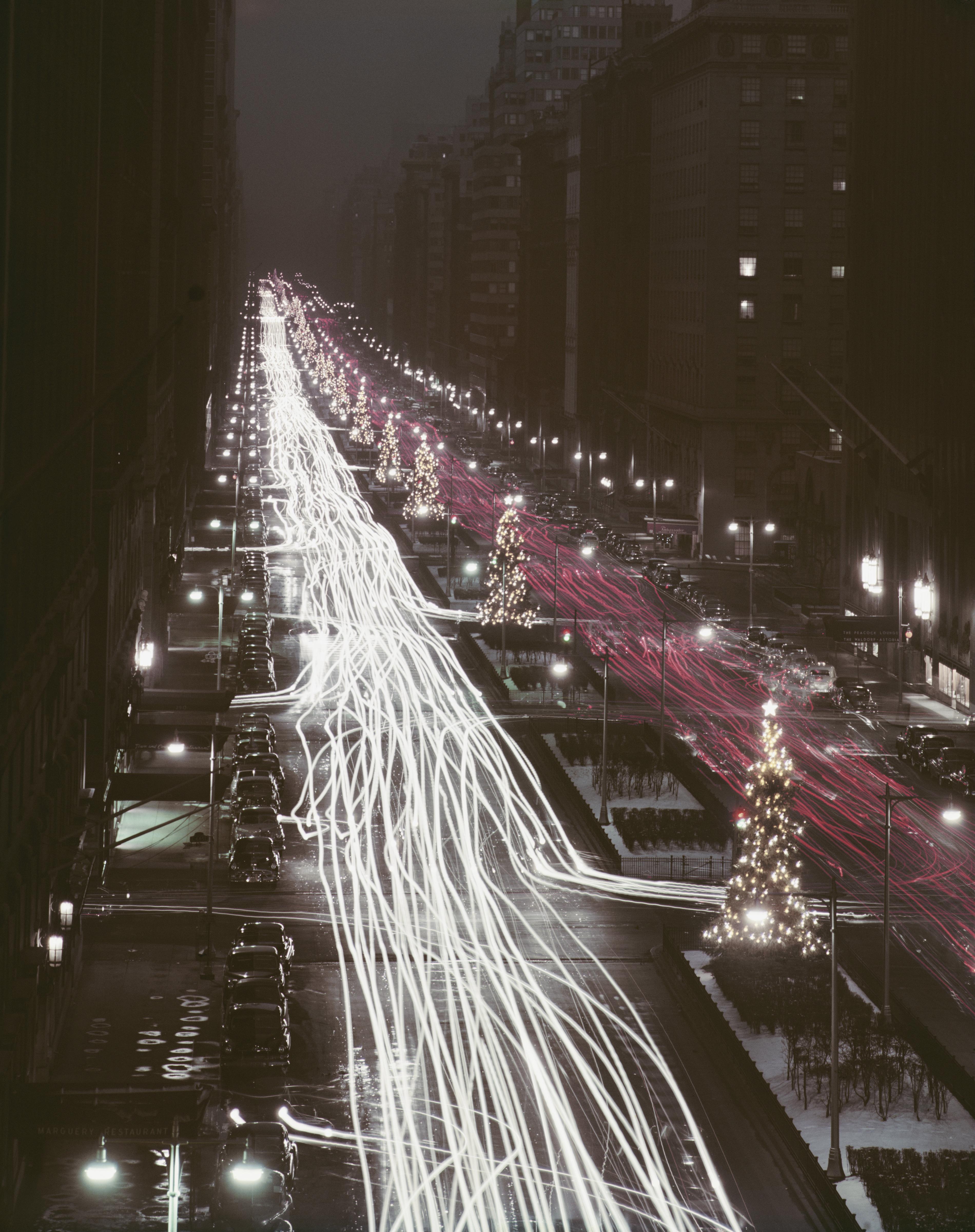 Christmas trees and red and white automobile light trails on Park Avenue, New York at Christmas time, December 1953. 

Once a year, we introduce never-before-seen Slim Aarons images! This is one of fifteen from our new collection. A word from our