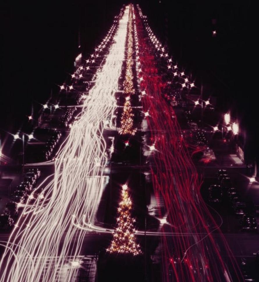 Christmas Traffic 
1953
by Slim Aarons

Slim Aarons Limited Estate Edition

Red and white automobile lights on Park Avenue, New York at Christmas time. The rear and headlights at nighttime give the appearance of lights on a giant Christmas tree,