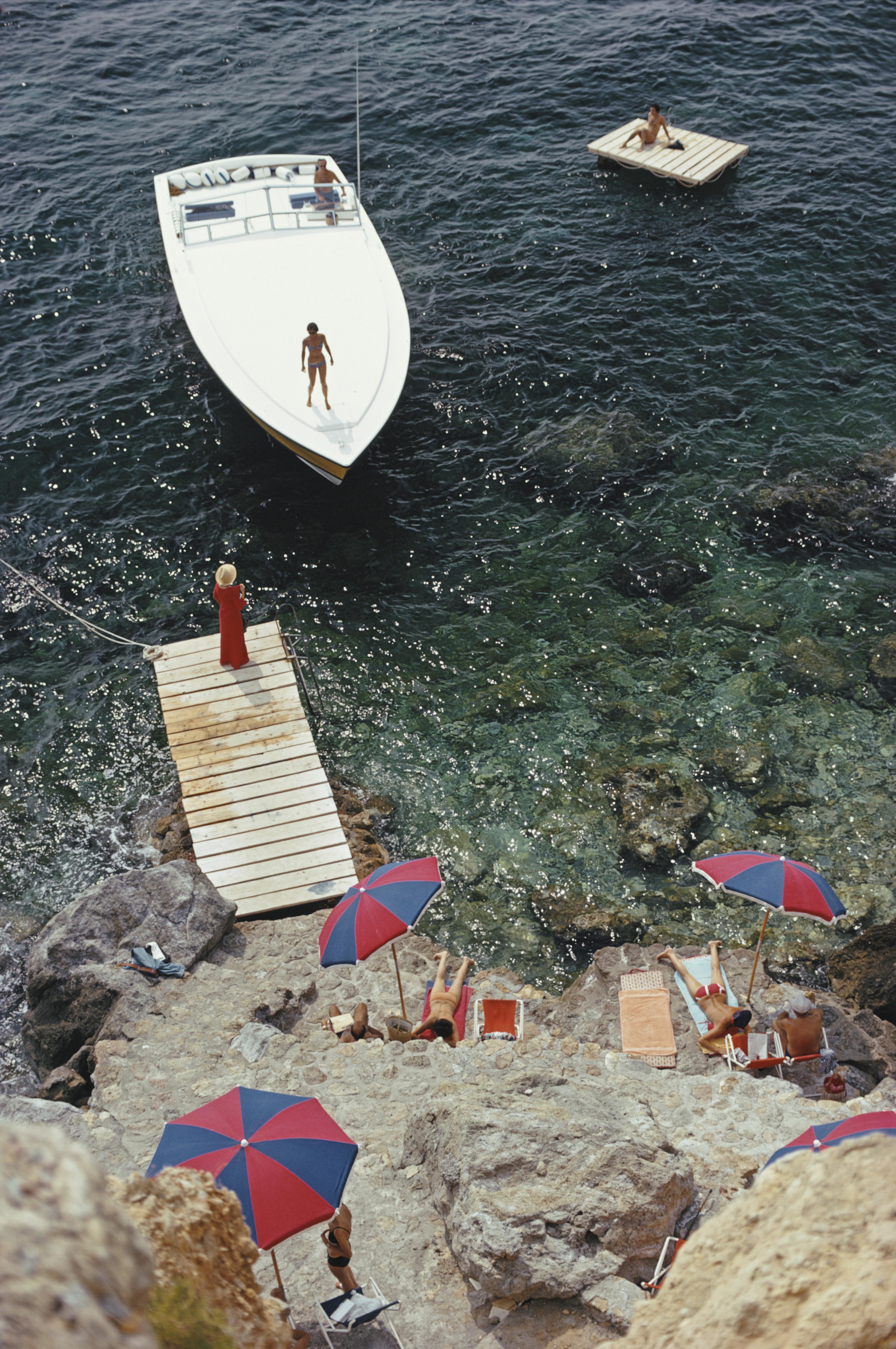 coming Ashore" 1973 Slim Aarons Edition limitée du domaine 

Un bateau à moteur Magnum appartenant au comte Filippo Theodoli arrive sur la jetée privée de l'hôtel Il Pellicano à Porto Ercole, en Italie. Août 1973. (Photo par Slim Aarons/Getty
